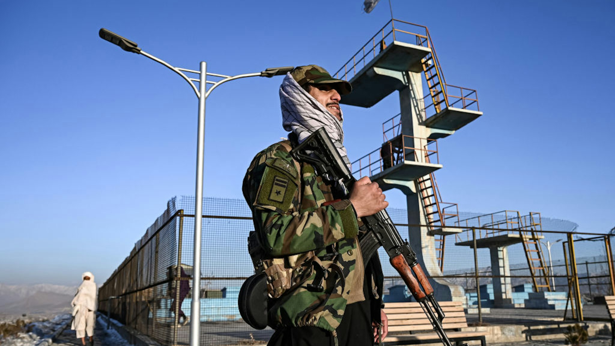 A Taliban fighter stands guard at the Wazir Akbar Khan hill in Kabul on January 31, 2022.