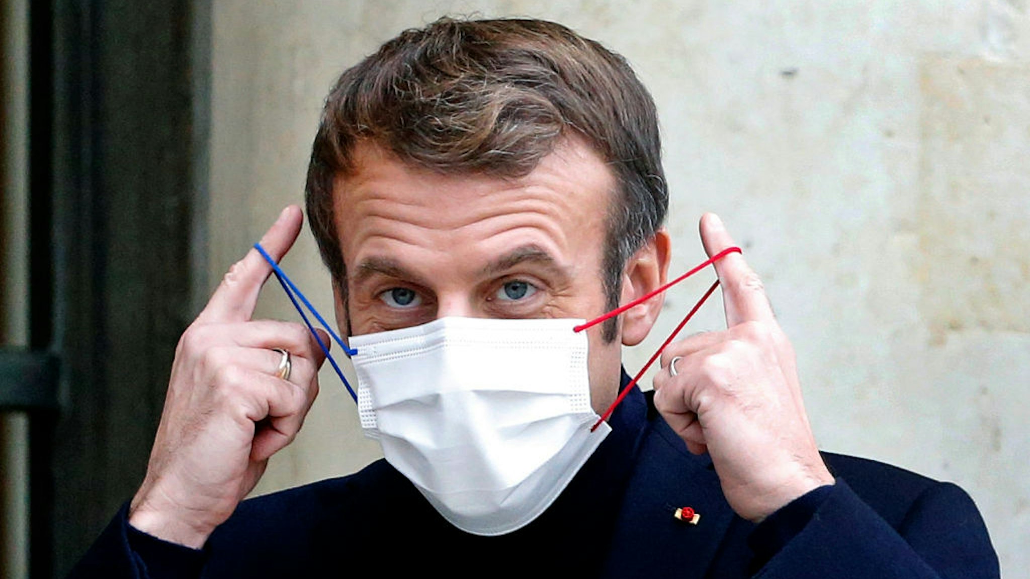 PARIS, FRANCE - DECEMBER 20: French President Emmanuel Macron takes off his protective face mask as he welcomes Rwanda's President Paul Kagame prior to their working lunch at the presidential Elysee Palace on December 20, 2021 in Paris, France. Emmanuel Macron receives Paul Kagame as part of the preparation for the summit between the European Union and the African Union to be held in February 2022 in Brussels. (Photo by Chesnot/Getty Images)