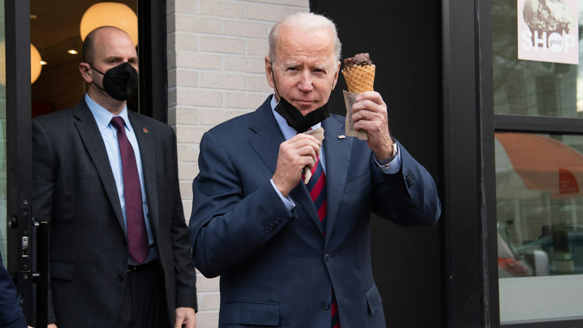 US President Joe Biden carries an ice cream cone as he leaves Jeni's Ice Cream in Washington, DC, on January 25, 2022.
