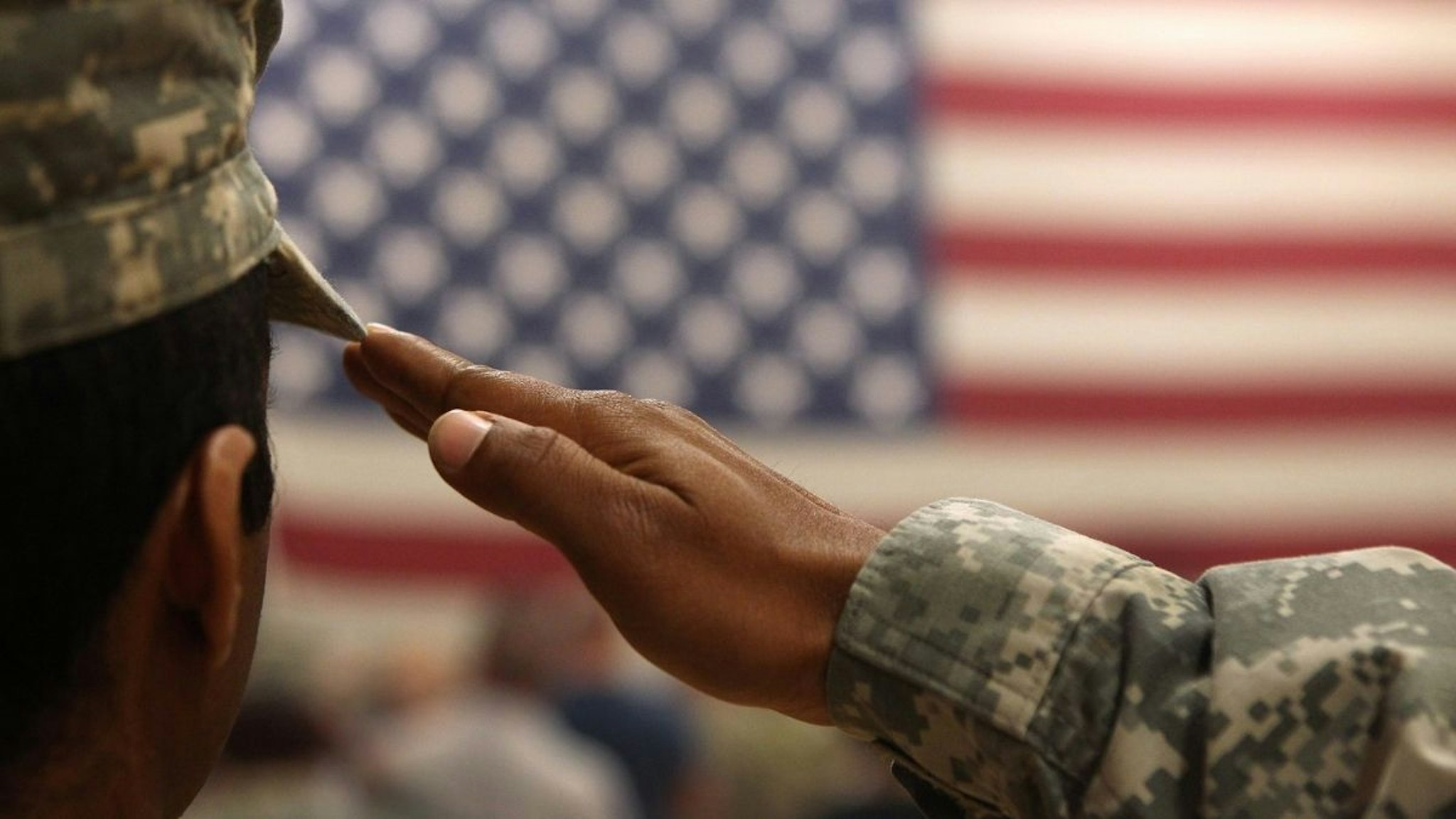 A soldier salutes the flag during a welcome home ceremony for troops arriving from Afghanistan on June 15, 2011 to Fort Carson, Colorado.