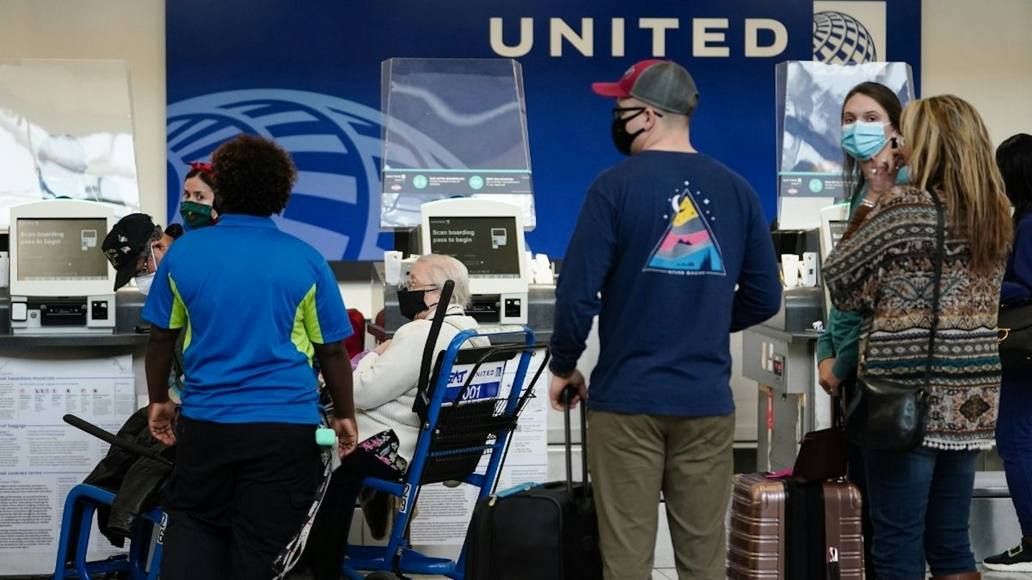Travelers wait to check in at the United Airlines ticket counter at Hartsfield-Jackson Atlanta International Airport (ATL) in Atlanta, Georgia, U.S., on Monday, Dec. 27, 2021.