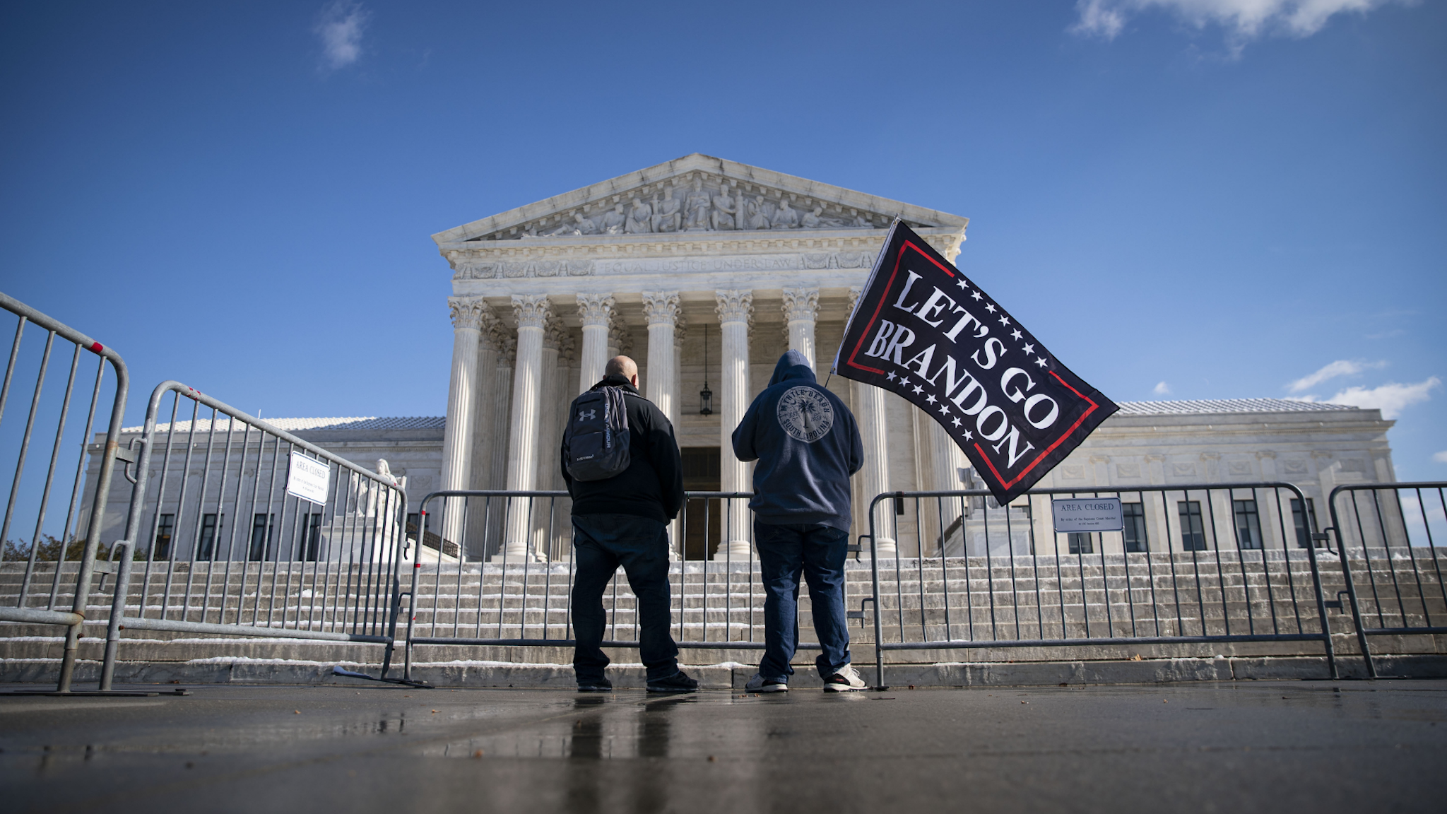A demonstrator waves a "Let's Go Brandon" flag outside of the U.S. Supreme Court during arguments on two federal coronavirus vaccine mandate measures in Washington, D.C., U.S., on Friday, Jan. 7, 2022.