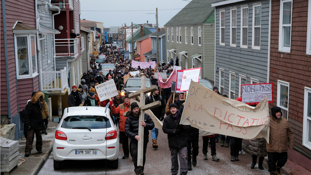 Protesters hold banners during a demonstration against Covid restrictions, the health and vaccine pass called by the "Together and free" (Ensemble et libre) association, in Saint-Pierre, in the French northern Atlantic archipelago of Saint-Pierre-et-Miquelon, on January 9, 2022.