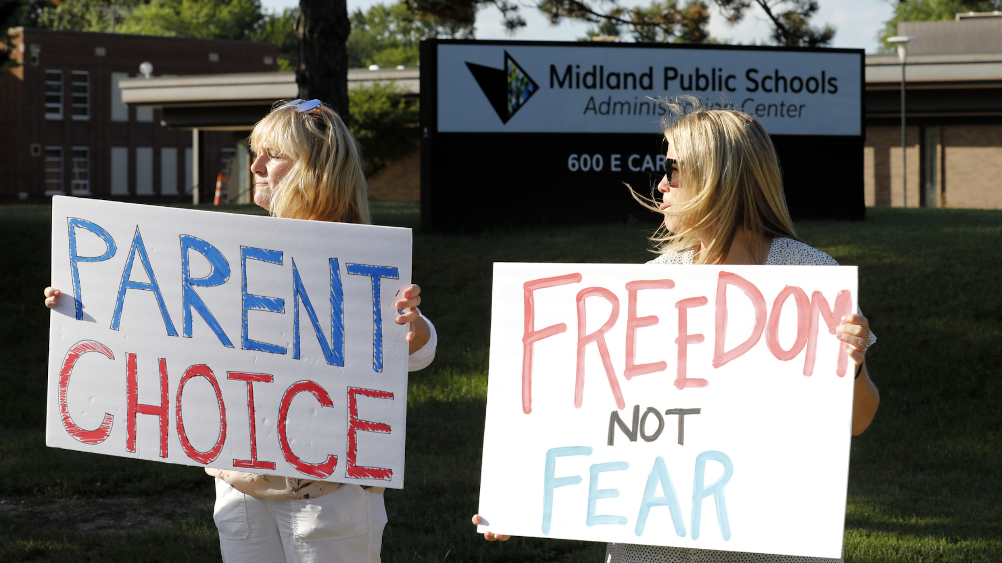 Demonstrators hold signs during a rally against the Midland Public Schools (MPS) mask mandates outside the MPS administration building in Midland, Michigan, U.S., on Wednesday, Sept. 1, 2021.
