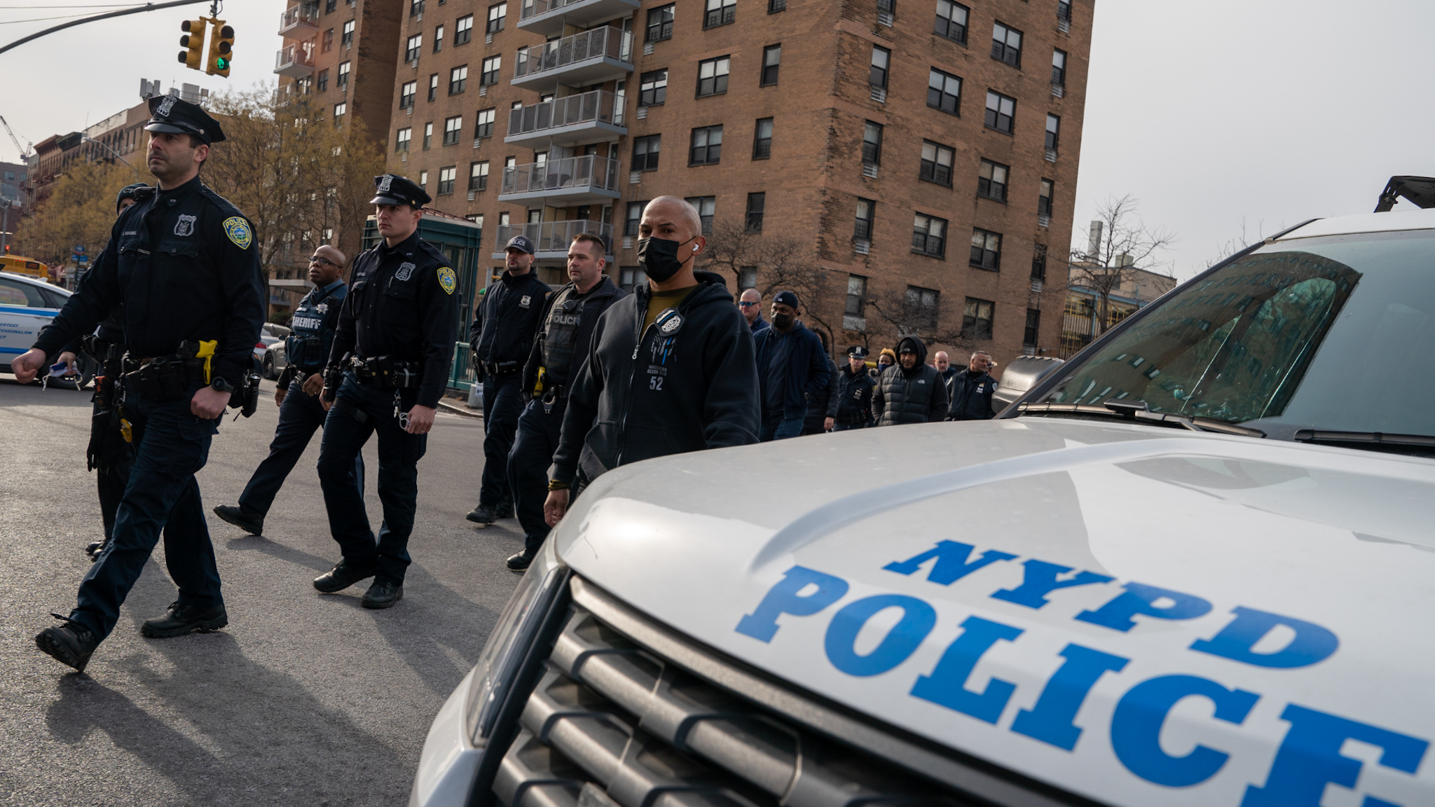 Police officers walk from the NYPD 32nd Precinct to Harlem Hospital near the scene where two officers where gunned down on January 23, 2022 in New York City. Officer Jason Rivera was killed in the attack. Officer Wilbert Mora was wounded and remains hospitalized.