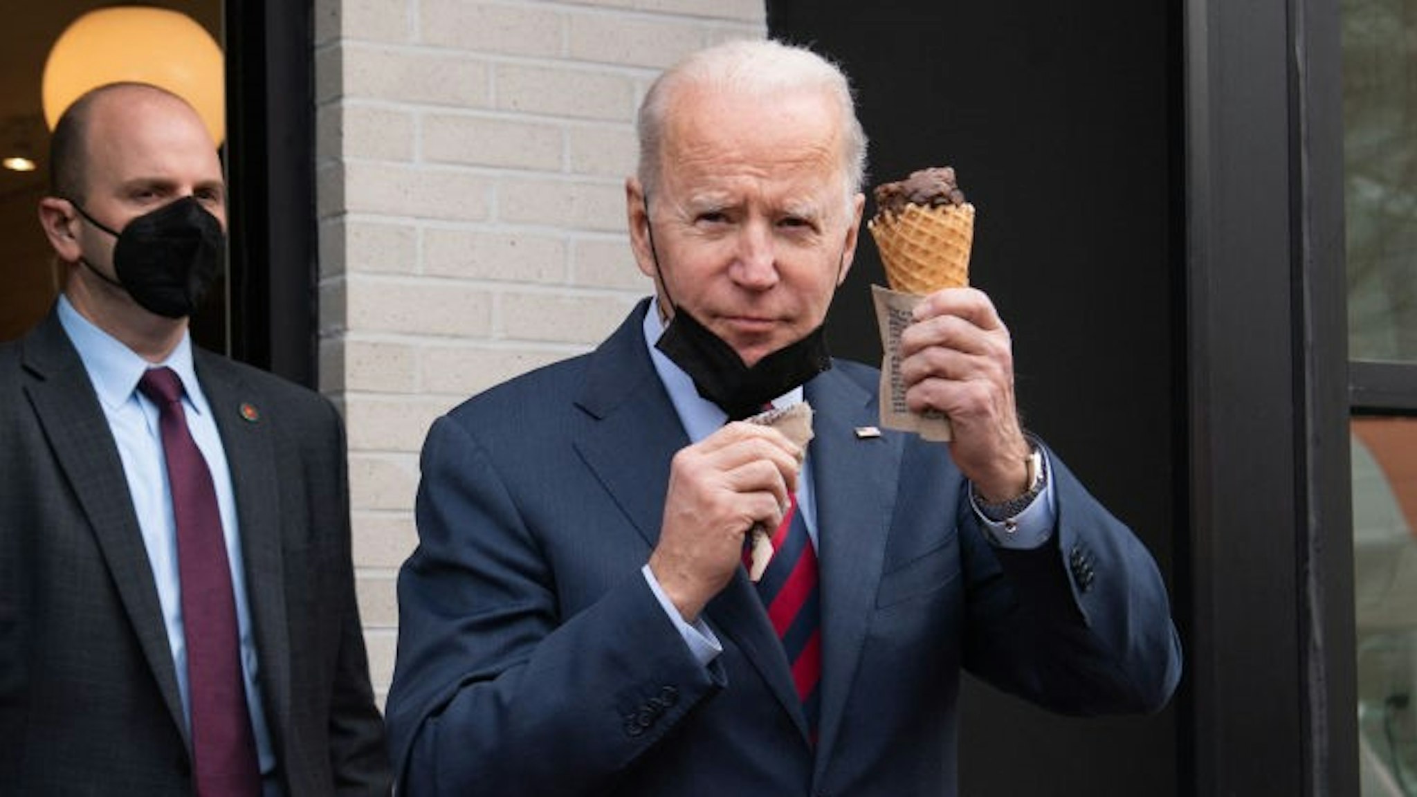 US President Joe Biden carries an ice cream cone as he leaves Jeni's Ice Cream in Washington, DC, on January 25, 2022. (Photo by SAUL LOEB / AFP) (Photo by