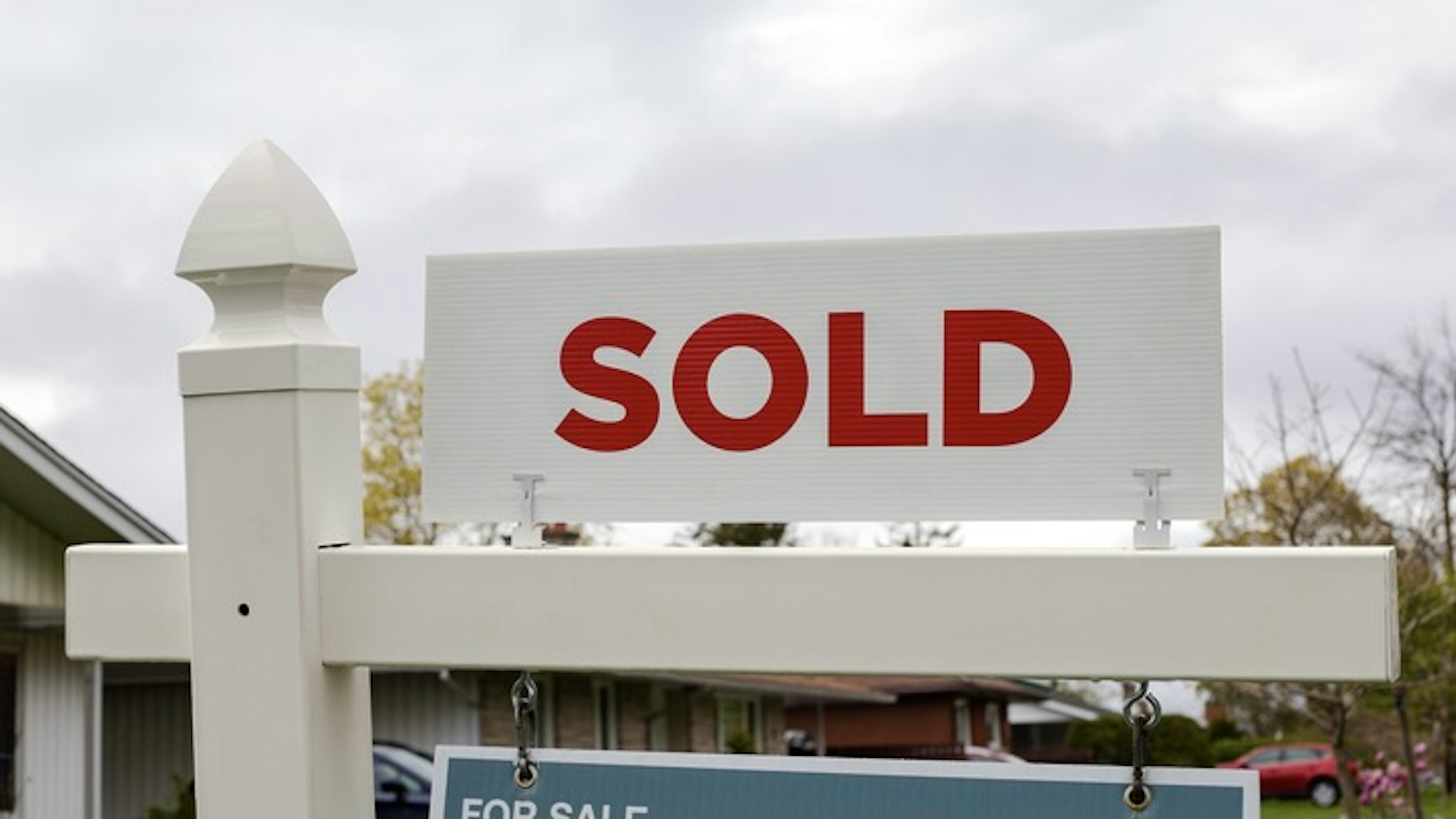 White sold sign in front of a house. Real estate concept - stock photo Sold sign in front of a house in a residential neighborhood Iryna Tolmachova via Getty Images