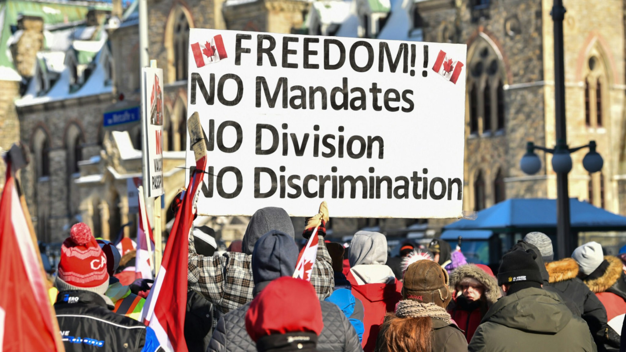 Protesters hold up a sign as they condemn the mandates imposed by the Prime Minister of Canada, Justin Trudeau near Parliament Hill on February 5, 2022 in Ottawa, Canada.