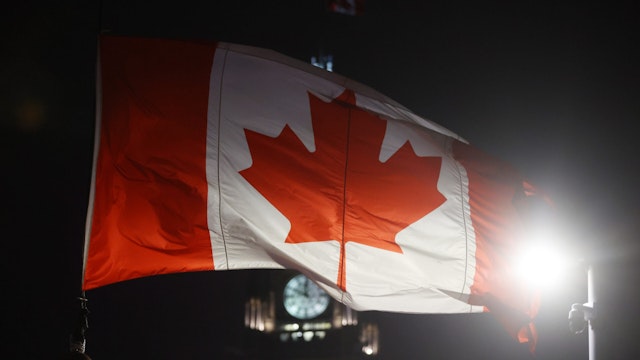A Canadian flag flies from a crane in front of the Peace Tower. After Ottawa Police handed out papers telling the truckers to leave or face arrest there was no movement on Wellington Street in front of Parliament Hill in Ottawa. February 16, 2022.