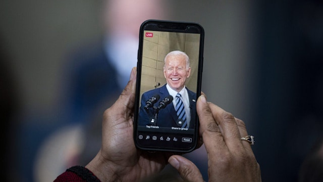An attendee uses Facebook Live to record U.S. President Joe Biden speaking during an event at Ironworkers Local 5 in Upper Marlboro, Maryland U.S., on Friday, Feb. 4, 2022.