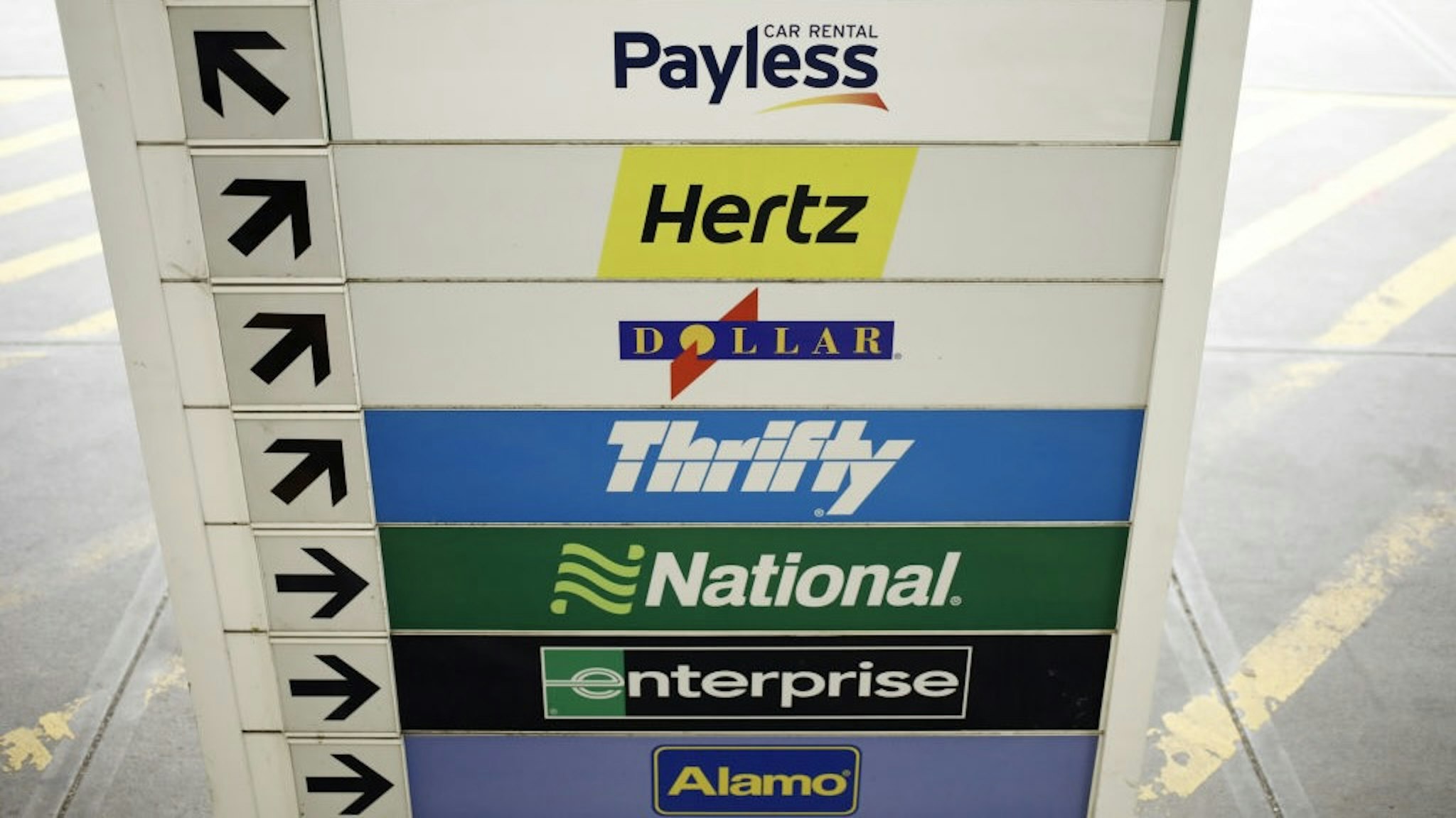 A Hertz Location As 2021 U.S. Car Rental Revenue Climbs 21% Budget, Payless, Hertz, Dollar, Thrifty, National, Enterprise and Alamo rental car signage at the Louisville International Airport in Louisville, Kentucky, U.S., on Thursday, Jan. 20, 2022. The U.S. car rental industry achieved overall revenues of $28.1 billion in 2021 - a 21% gain over the pandemic year of 2020, according to data collected by Auto Rental News. Photographer: Luke Sharrett/Bloomberg via Getty Images Bloomberg / Contributor