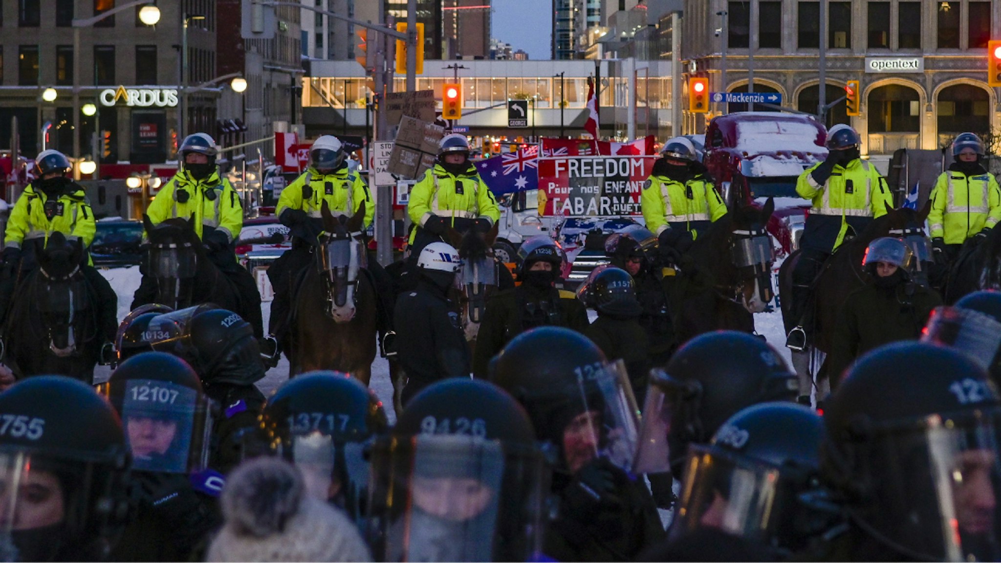 Horse-mounted law enforcement officers form a line during a demonstration in Ottawa, Ontario, Canada, on Friday, Feb. 18, 2022. Police have begun an extensive operation to lock down the city center of Ottawa to clear the streets of demonstrators, along with dozens of semi-trailers.