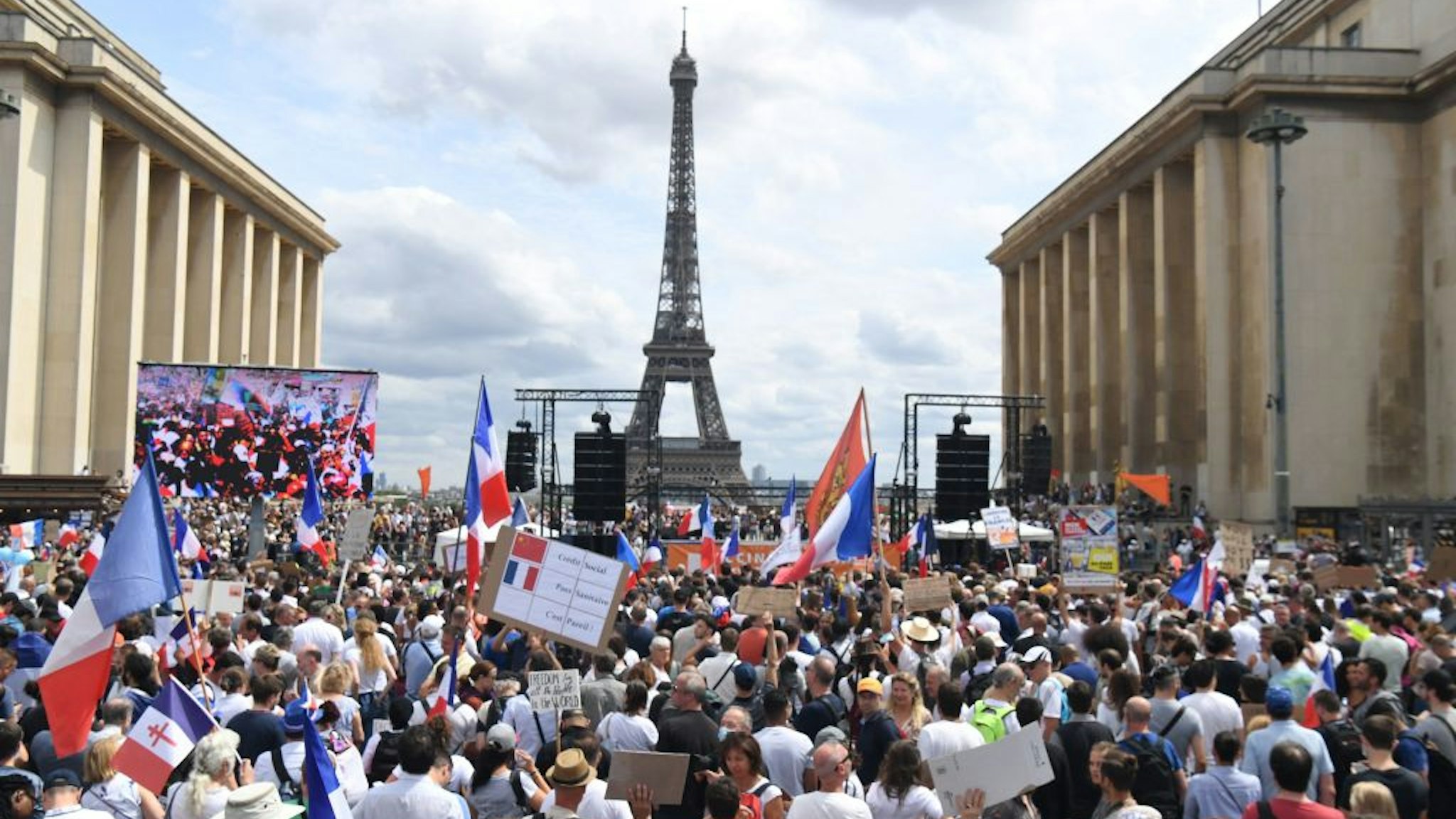 TOPSHOT - Protesters take part in a protest against the compulsory vaccination for certain workers and the mandatory use of the health pass called by the French government, on the "Droits de l'homme" (human rights) esplanade at the Trocadero Square, in front of the Eiffel Tower in Paris on July 24, 2021. - Since July 21, people wanting to go to in most public spaces in France have to show a proof of Covid-19 vaccination or a negative test, as the country braces for a feared spike in cases from the highly transmissible Covid-19 Delta variant.