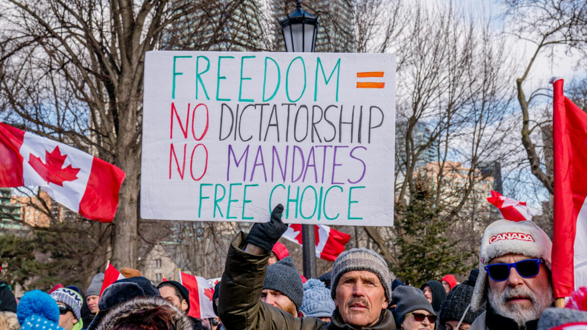 A protester holds a sign that says Freedom = No dictatorship, no mandates free choice during the Anti-Vaccine Mandate rally.
