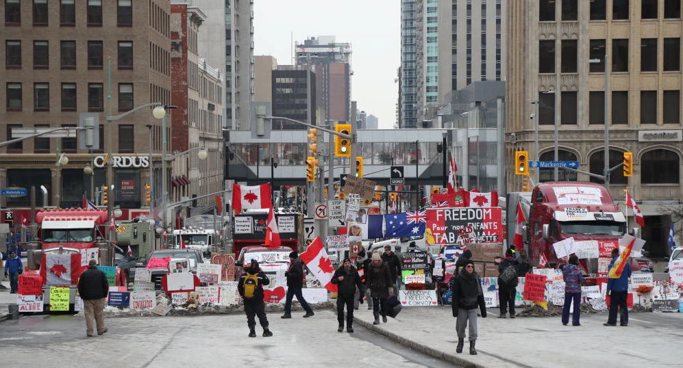 Trucks and protesters block a downtown street during a demonstration in Ottawa, Ontario, Canada, on Wednesday, Feb. 16, 2022. Demonstrations around Ottawa's parliamentary precinct are now prohibited by Prime Minister Trudeau's order, which also instructs banks to cut off funding and services to anyone who is either participating in the blockade or providing support to it. Photographer: