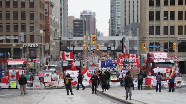 Trucks and protesters block a downtown street during a demonstration in Ottawa, Ontario, Canada, on Wednesday, Feb. 16, 2022. Demonstrations around Ottawa's parliamentary precinct are now prohibited by Prime Minister Trudeau's order, which also instructs banks to cut off funding and services to anyone who is either participating in the blockade or providing support to it. Photographer: