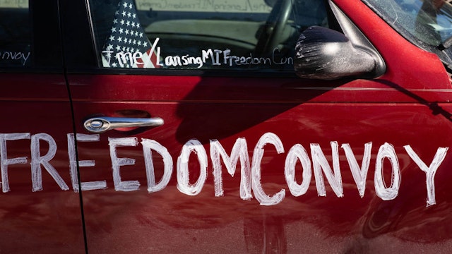 LANSING, MI - FEBRUARY 20: Cars line up with messages, signs and flags as people gather for a Freedom Convoy protesting Covid restrictions and demanding election audits on February 20, 2022 in Lansing, Michigan. The Freedom Convoy has been circling the Michigan State Capitol daily while simultaneously honking horns in support of ongoing protests in Canada. (Photo by Emily Elconin/Getty Images)