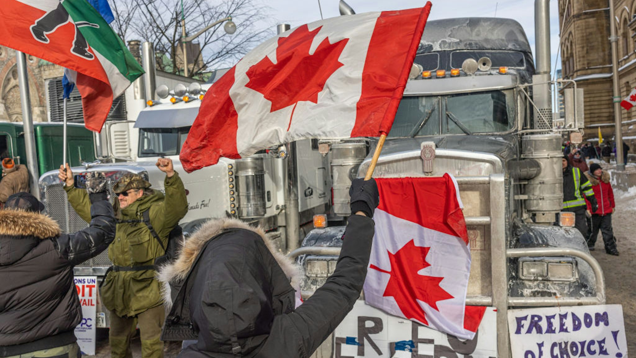 OTTAWA, ON - JANUARY 30: A woman waves a flag and cheers on truckers in protest of COVID-19 vaccine mandates on January 30, 2022 in Ottawa, Canada. Thousands turned up over the weekend to rally in support of truckers using their vehicles to block access to Parliament Hill, most of the downtown area Ottawa, and the Alberta border in hopes of pressuring the government to roll back COVID-19 public health regulations. (Photo by Alex Kent/Getty Images)