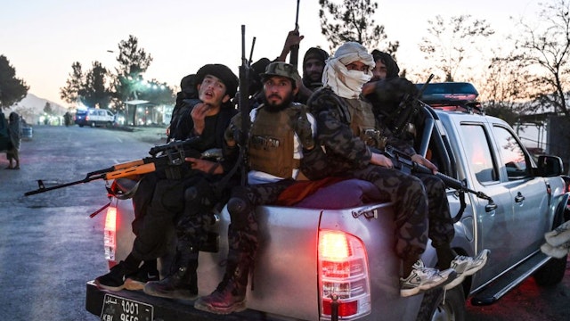 In this picture taken on November 19, 2021 Taliban fighters travel on a pick-up truct as they leave from an amusement park near the Qargha Lake on the outskirts of Kabul.