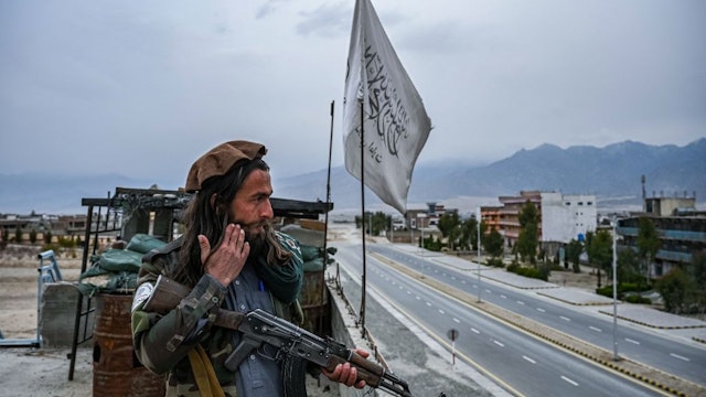 A Taliban fighter mans a post on the roof top of the main gate of Laghman University in Mihtarlam, Laghman province on February 2, 2022.(