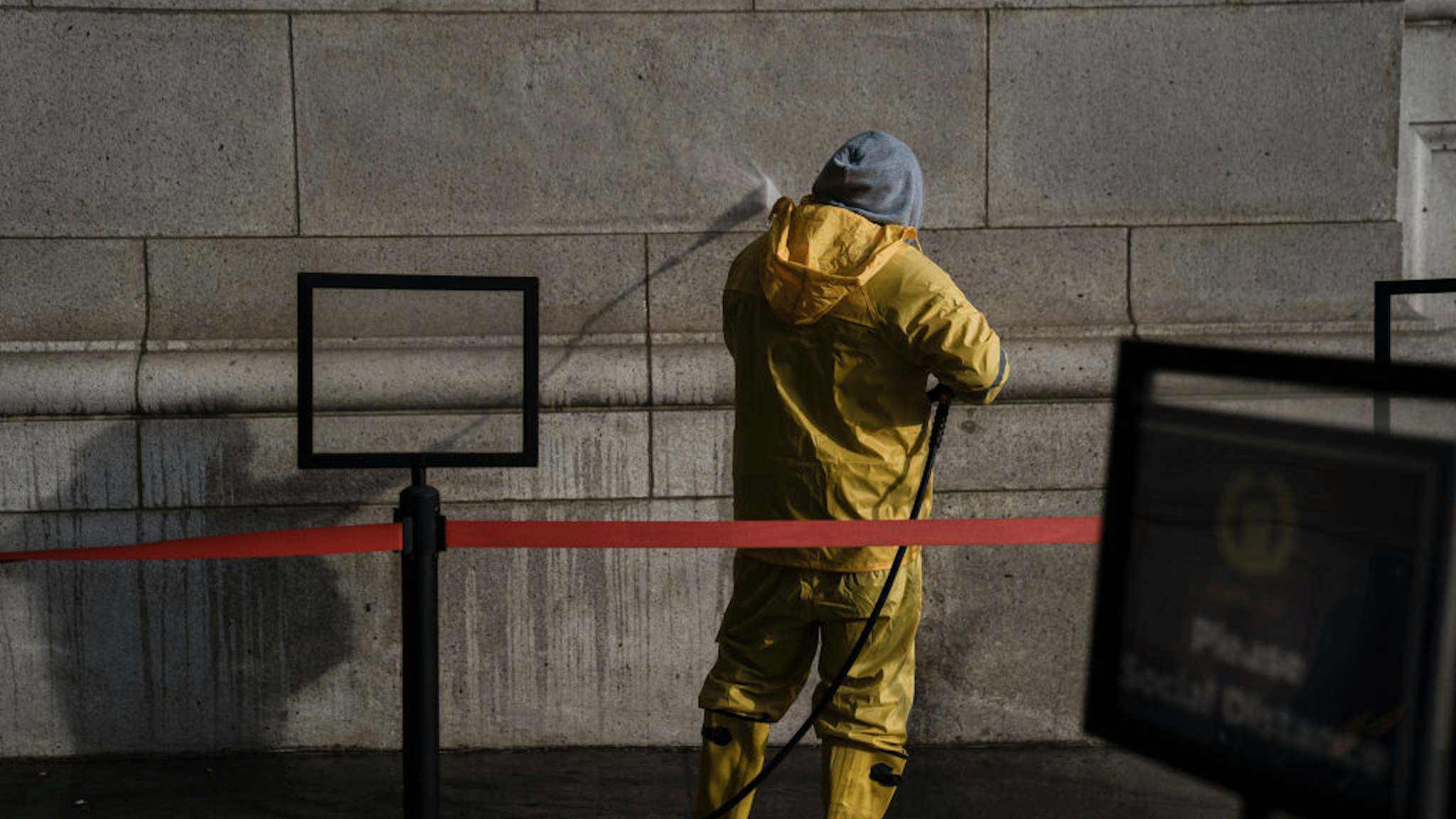 A worker pressure washes a wall at Union Station to clean off swastikas and anti-Obama slogans that were drawn on the exterior of the building on Wednesday, Feb. 2, 2022 in Washington, DC.