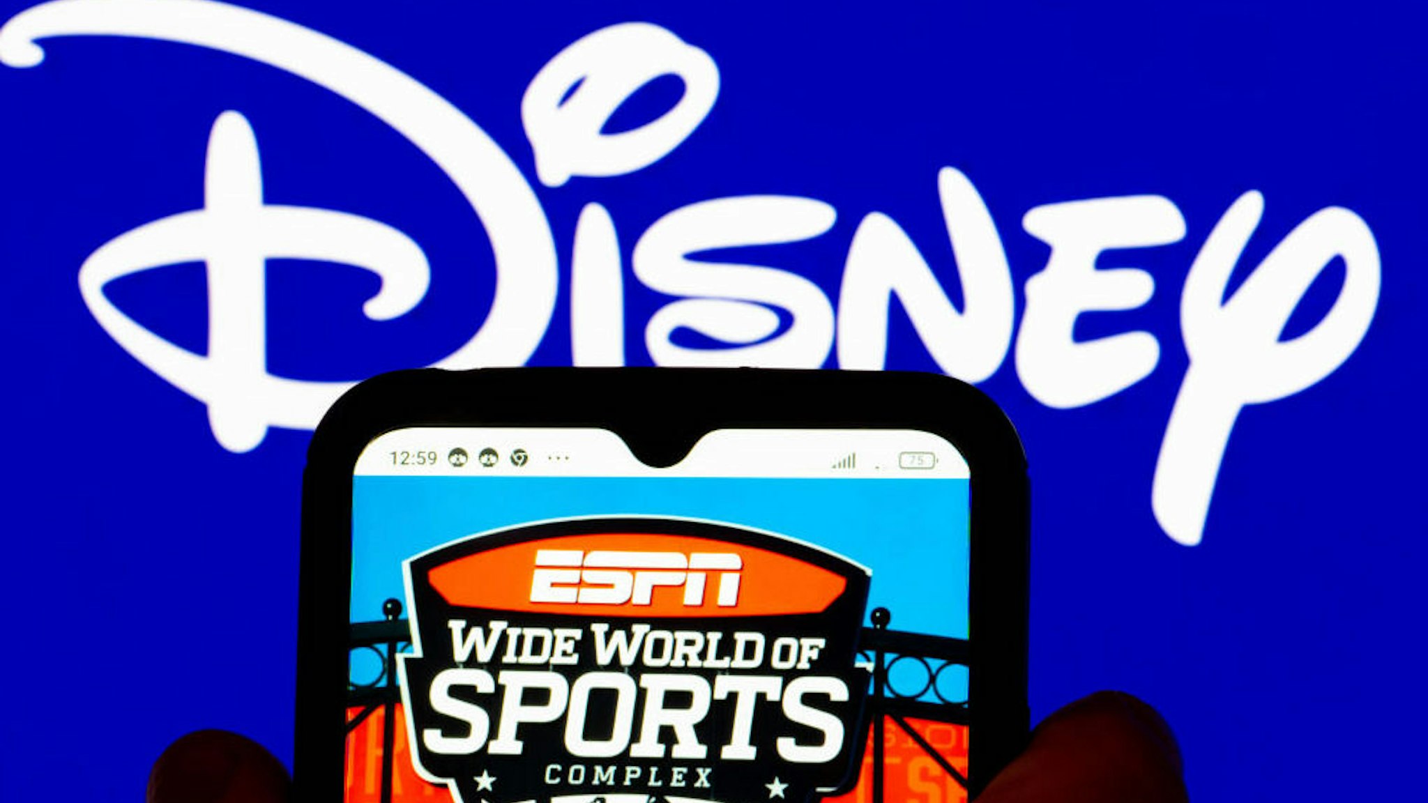 UKRAINE - 2022/02/07: In this photo illustration, the ESPN Wide World of Sport Complex logo is displayed on a smartphone screen with the Disney logo in the background. (Photo Illustration by Igor Golovniov/SOPA Images/LightRocket via Getty Images)