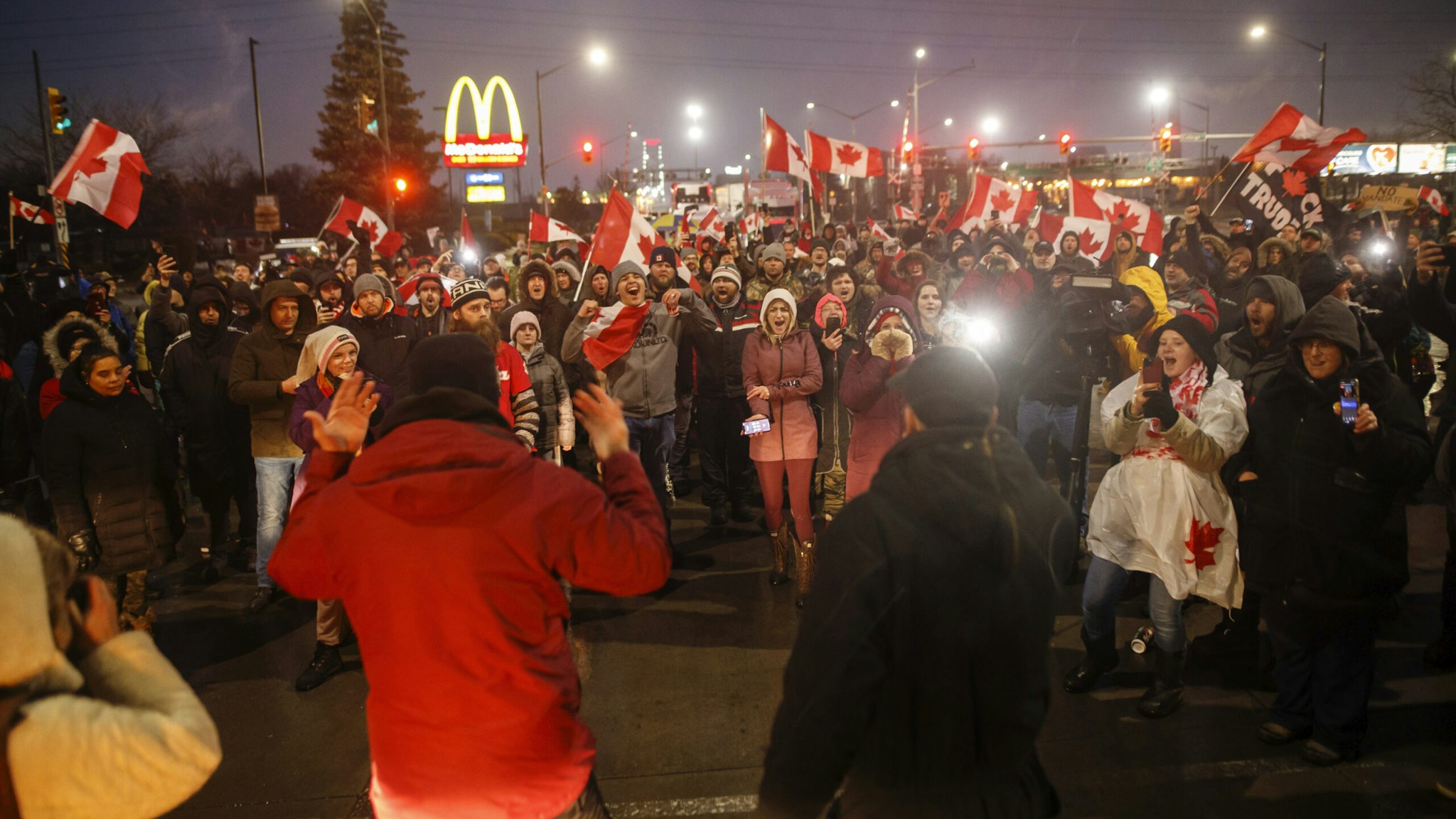 Protestors and supporters take a vote on whether to stay or leave ahead of an impending 7PM injunction deadline at the foot of the Ambassador Bridge, sealing off the flow of commercial traffic over the bridge into Canada from Detroit, on February 11, 2022 in Windsor, Canada.