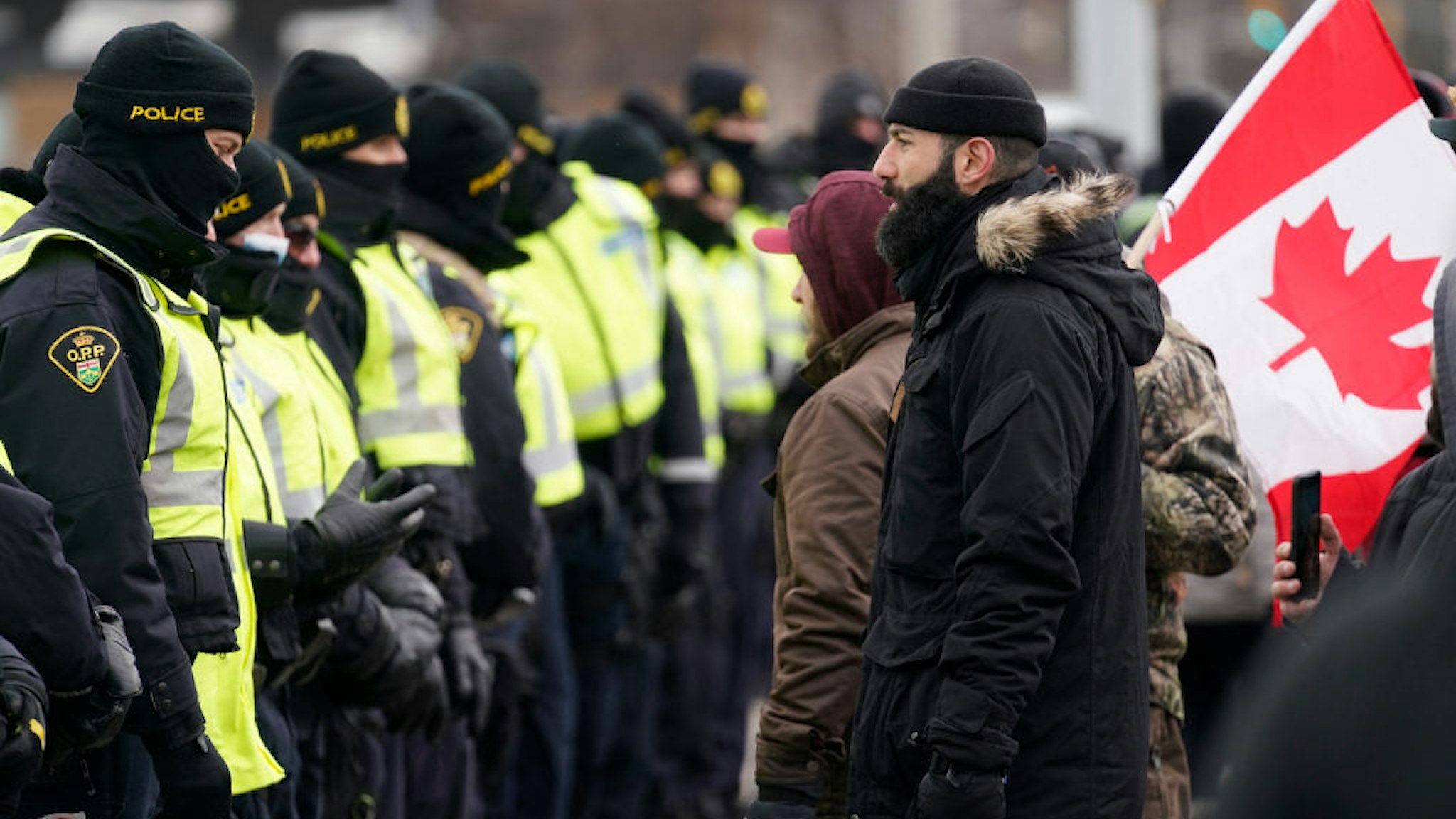 Canadian police deploy on February 12, 2022, to move protesters blocking access to the Ambassador Bridge and demanding an end to government Covid-19 mandates, in Windsor, Ontario.