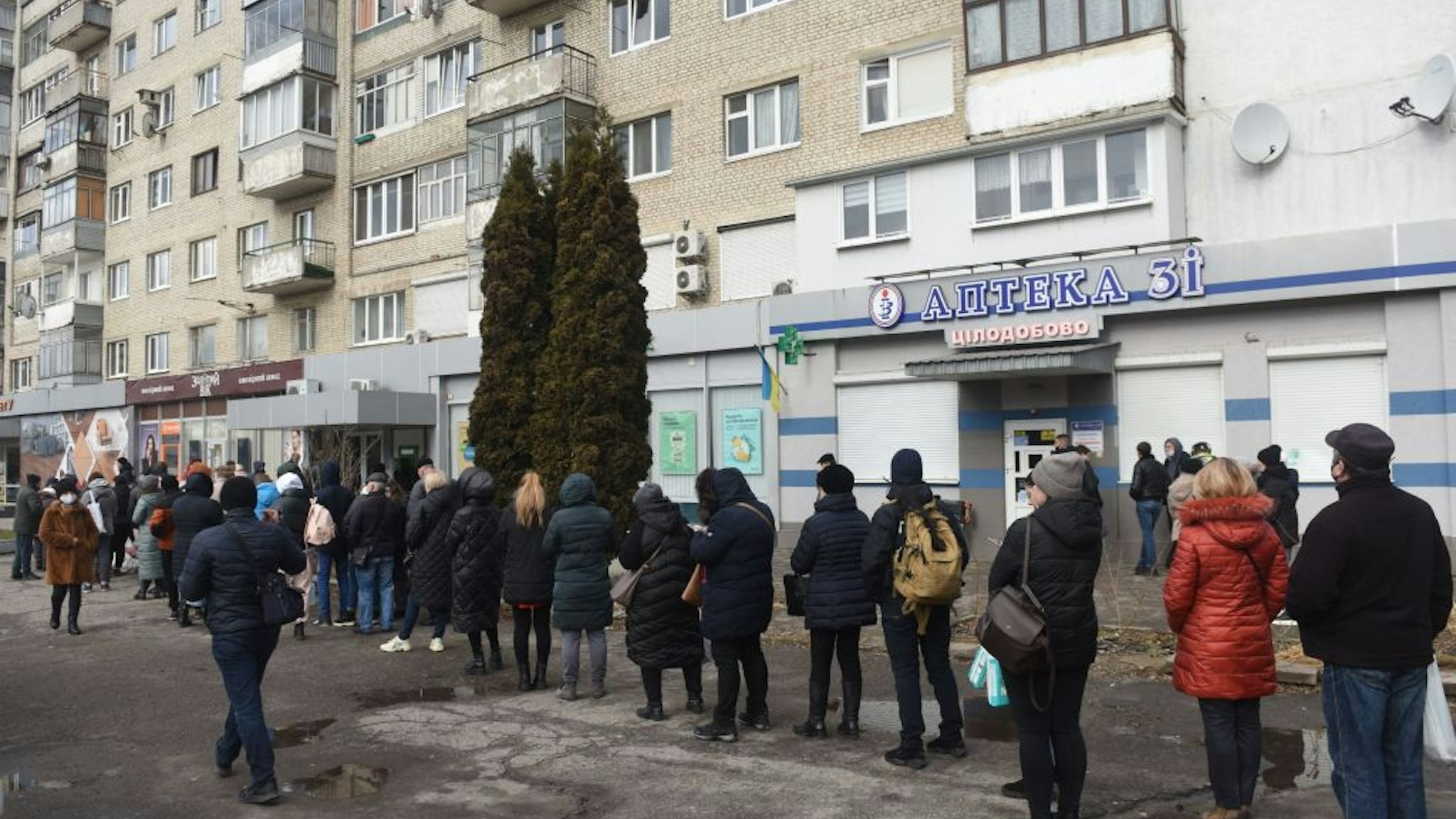 People queue to withdraw money at cash machines in the western Ukrainian city of Lviv on February 24, 2022.