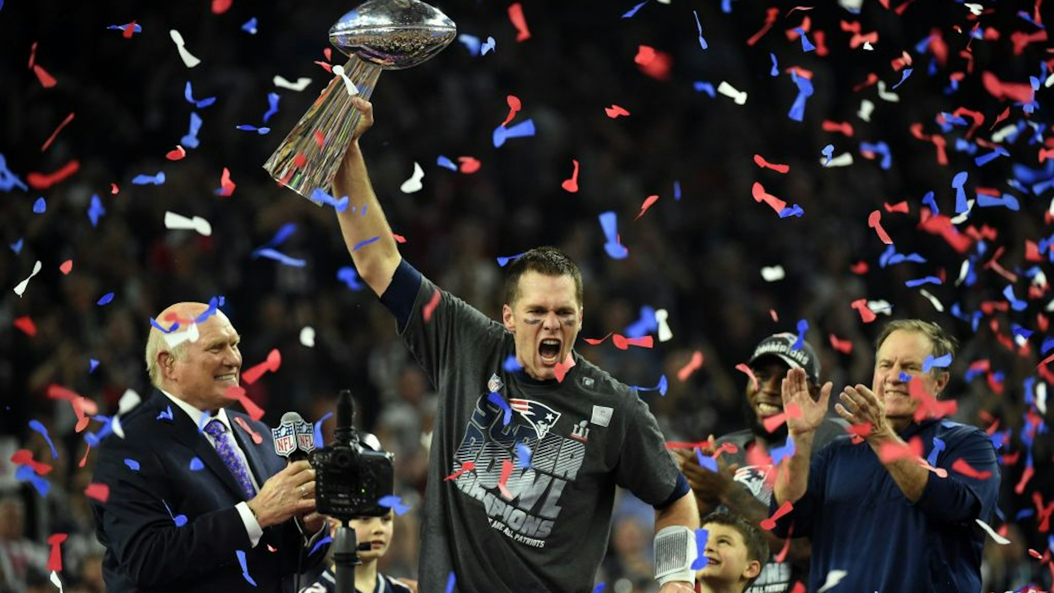 TOPSHOT - Tom Brady #12 of the New England Patriots holds the Vince Lombardi Trophy as Head coach Bill Belichick (R) looks on after defeating the Atlanta Falcons 34-28 in overtime during Super Bowl 51 at NRG Stadium on February 5, 2017 in Houston, Texas. The Patriots defeated the Falcons 34-28 after overtime. / AFP PHOTO / Timothy A. CLARY (Photo credit should read TIMOTHY A. CLARY/AFP via Getty Images)