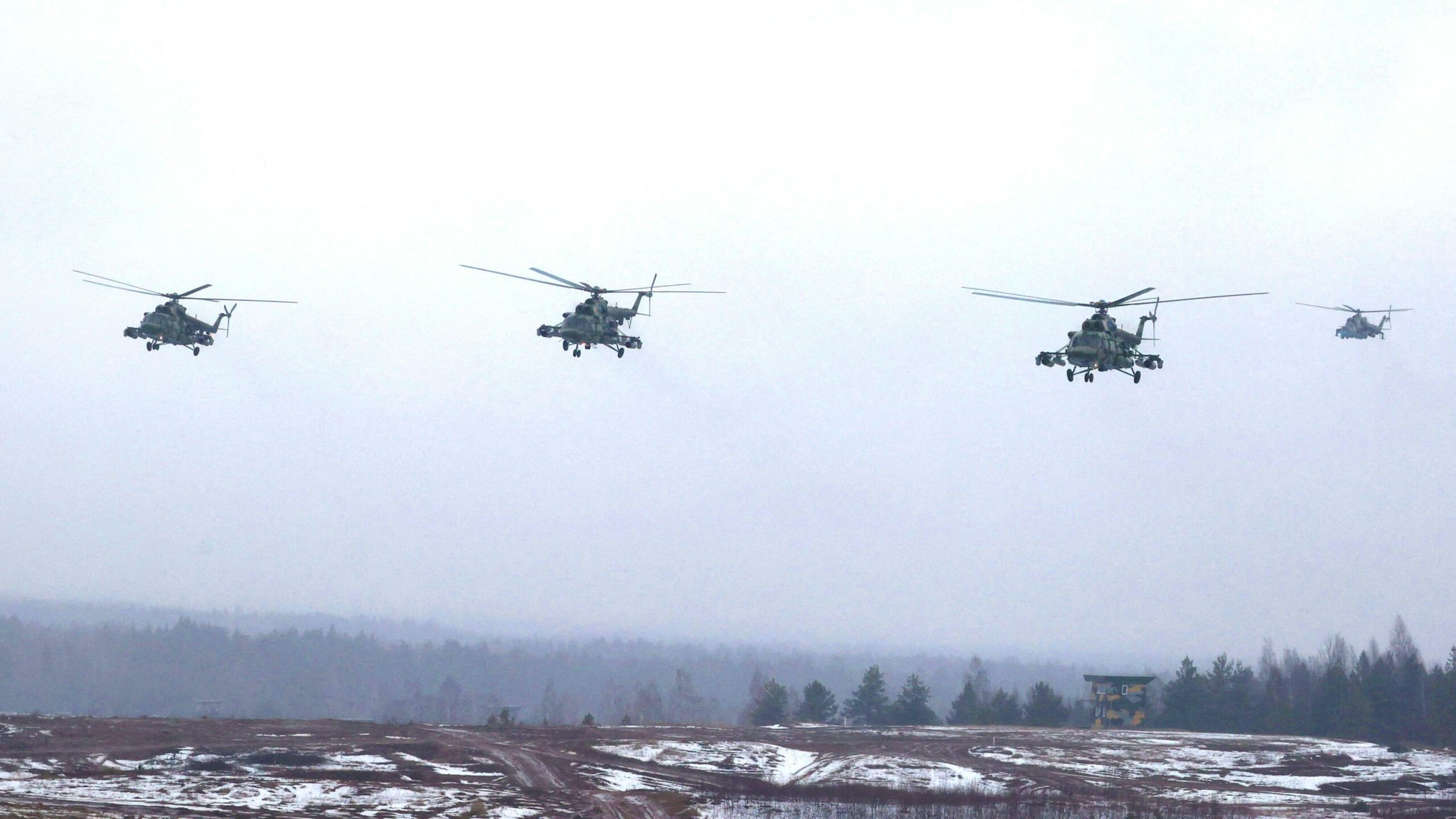 Belarusian Mil Mi-8MTV-5 military helicopters fly over a field during joint exercises of the armed forces of Russia and Belarus as part of an inspection of the Union State's Response Force, at a firing range near a town of Osipovichi outside Minsk on February 17, 2022.