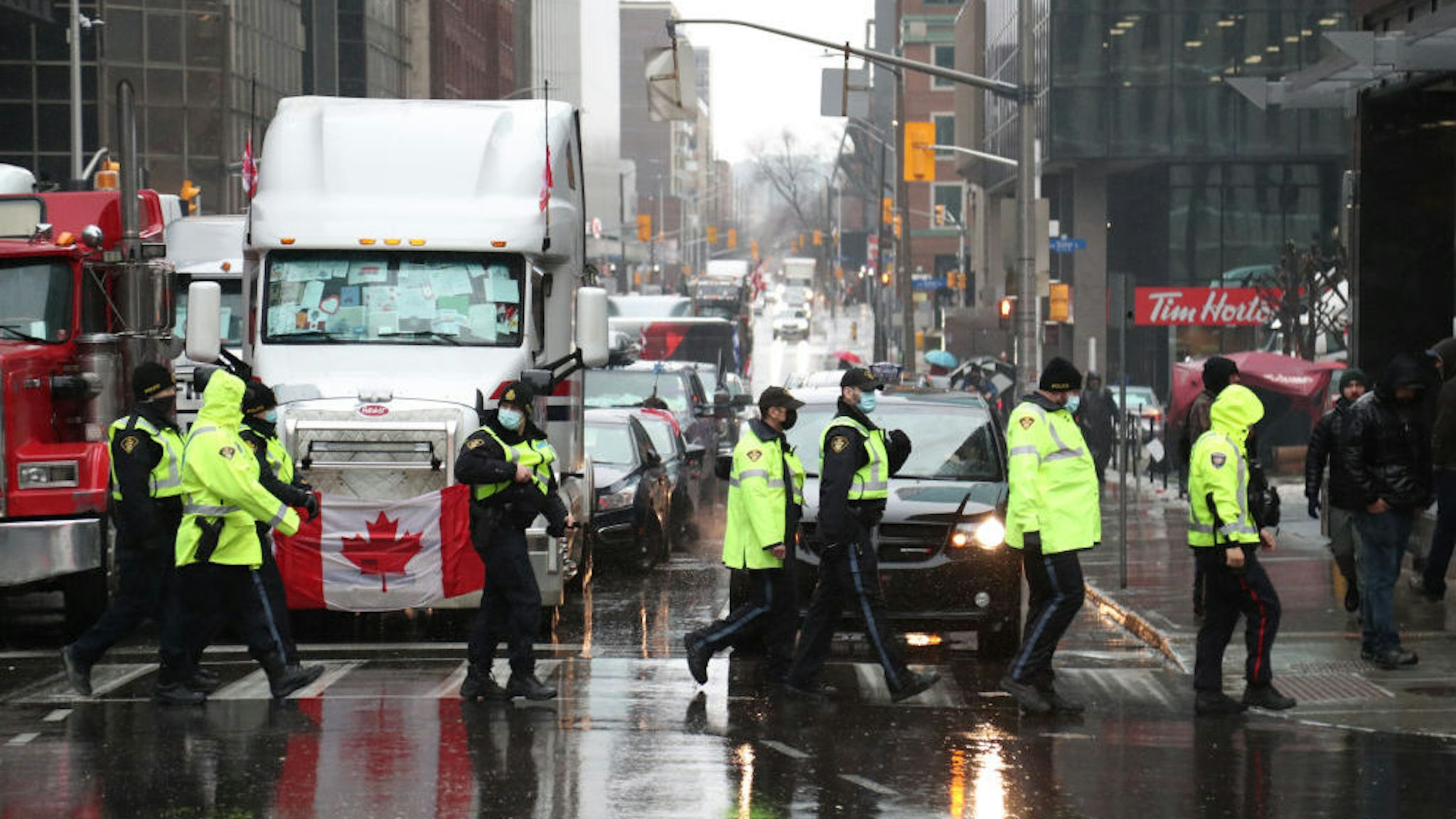 Police officers walk past trucks blocking a street during a demonstration in Ottawa, Ontario, Canada, on Thursday, Feb. 17, 2022. Police told demonstrators camped out on the streets of Canada’s capital that they must leave or be subject to arrest under new emergency powers invoked by Prime Minister Justin Trudeau and Ontario’s provincial government. Photographer: David Kawai/Bloomberg