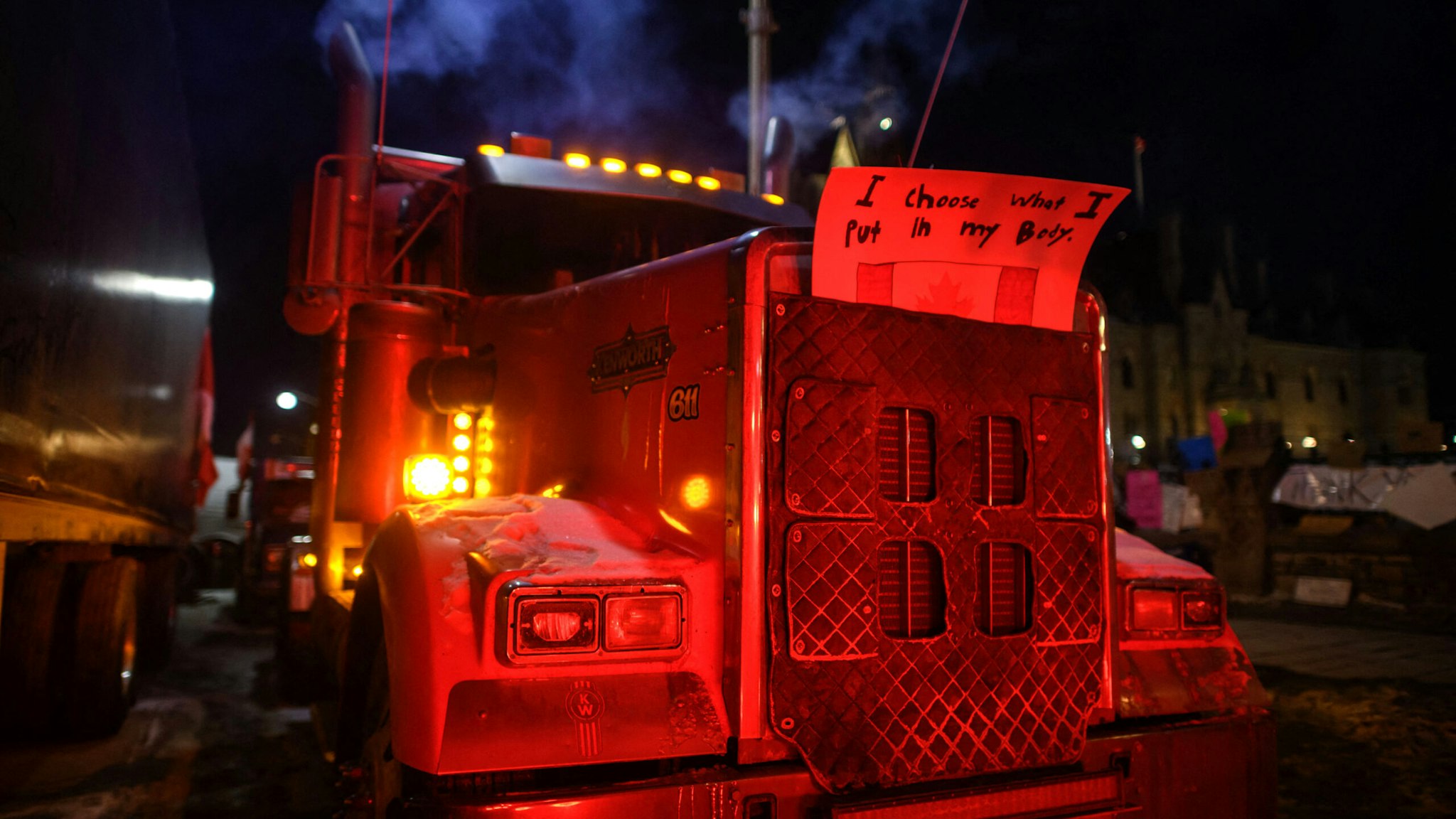 TOPSHOT - A slogan is displayed on the frot of a truck blocking a road during a protest by truck drivers over pandemic health rules and the Trudeau government, outside the parliament of Canada in Ottawa on February 14, 2022. - Canadian Prime Minister Justin Trudeau on Monday invoked rarely used emergency powers to bring an end to trucker-led protests against Covid health rules, after police arrested 11 people with a "cache of firearms" blocking a border crossing with the United States.