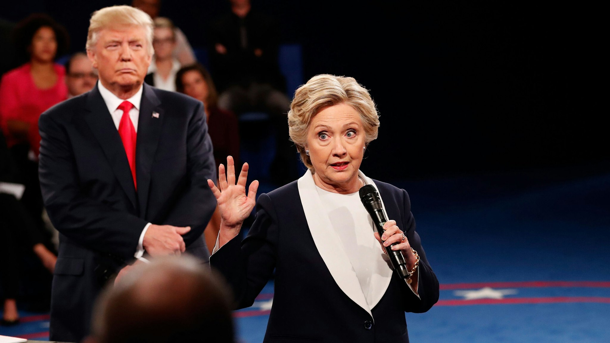 ST LOUIS, MO - OCTOBER 09: Democratic presidential nominee former Secretary of State Hillary Clinton (R) speaks as Republican presidential nominee Donald Trump listens during the town hall debate at Washington University on October 9, 2016 in St Louis, Missouri. This is the second of three presidential debates scheduled prior to the November 8th election.