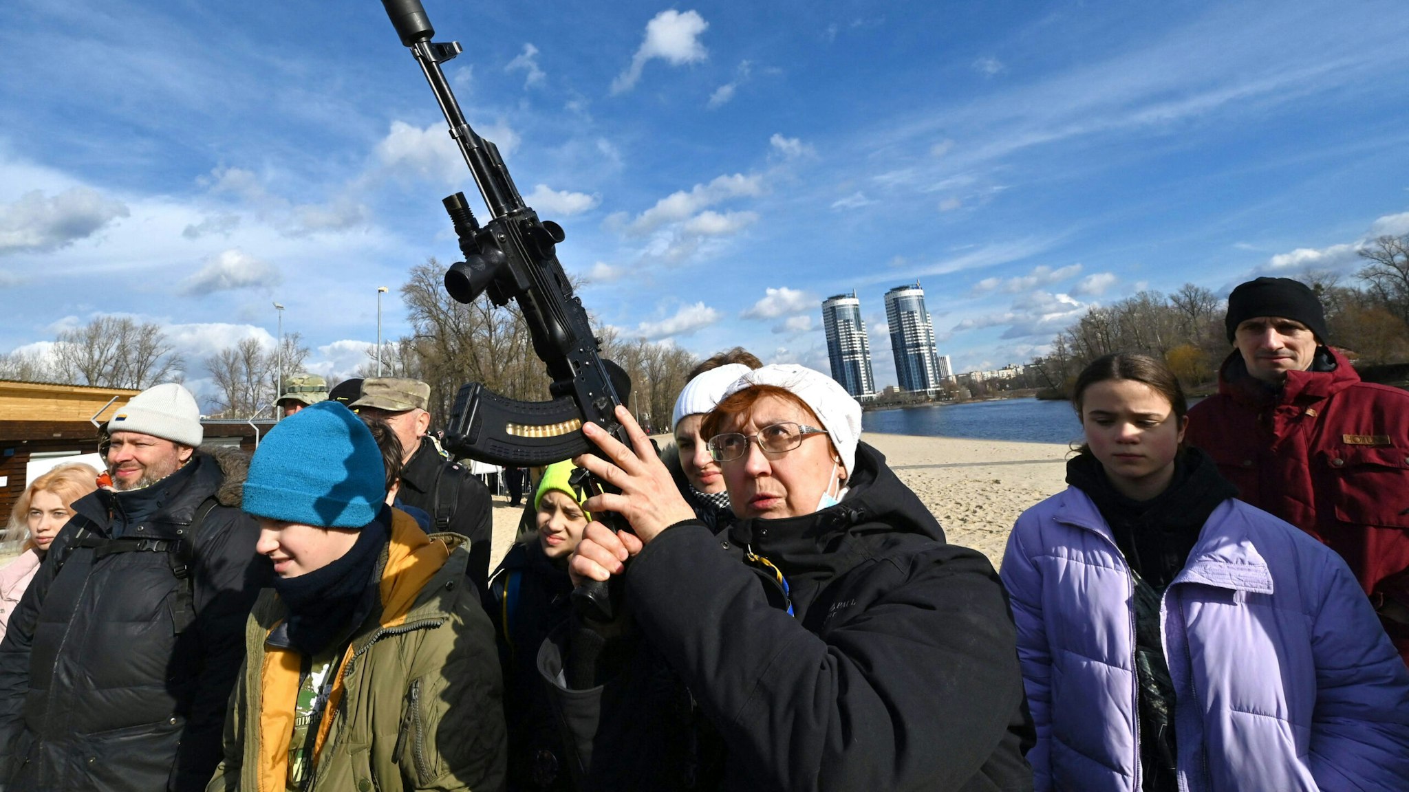 TOPSHOT - Residents attend an open training organised for civilians by war veterans and volunteers who teach the basic weapons handling and first aid on one of Kiyv's city beaches on February 20, 2022, amid soaring tensions with Russia.