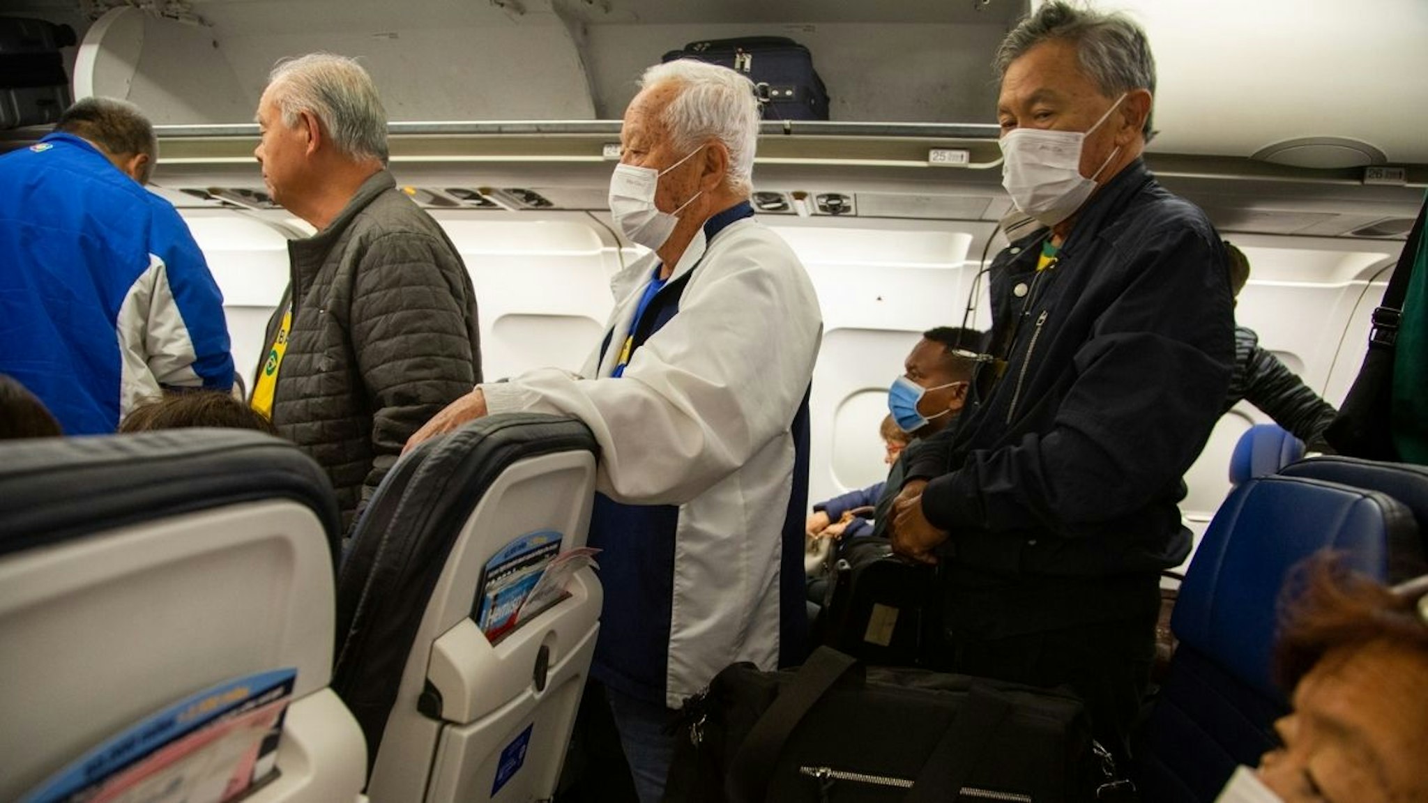 Passengers wear protective face masks in a airplane after arrival in Houston International Airport on March 14, 2020 in Houston, Texas.