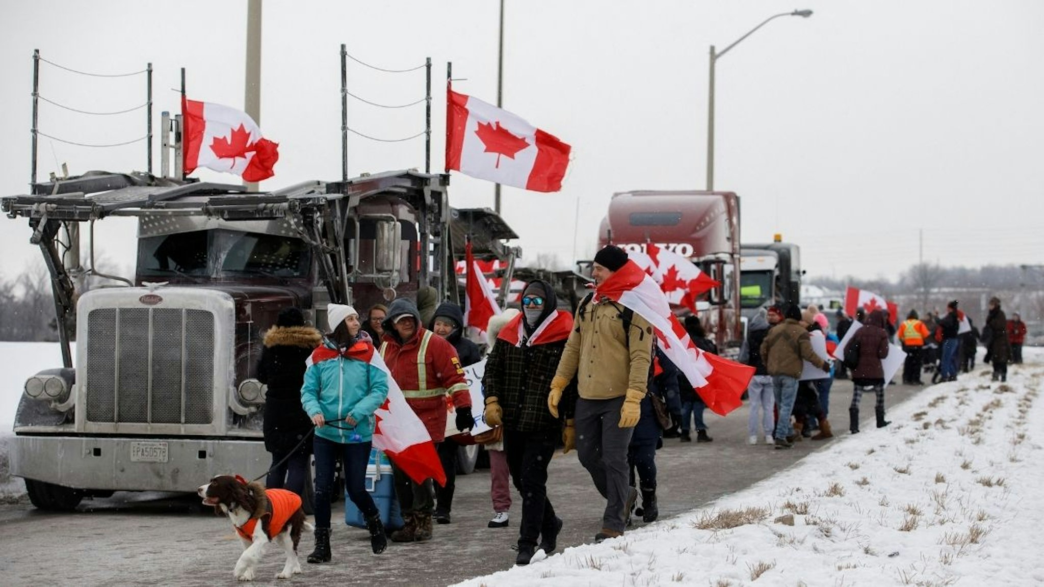 Supporters for a convoy of truckers driving from British Columbia to Ottawa in protest of a Covid-19 vaccine mandate for cross-border truckers, gather near a highway overpass outside of Toronto, Ontario, Canada, on January 27, 2022.