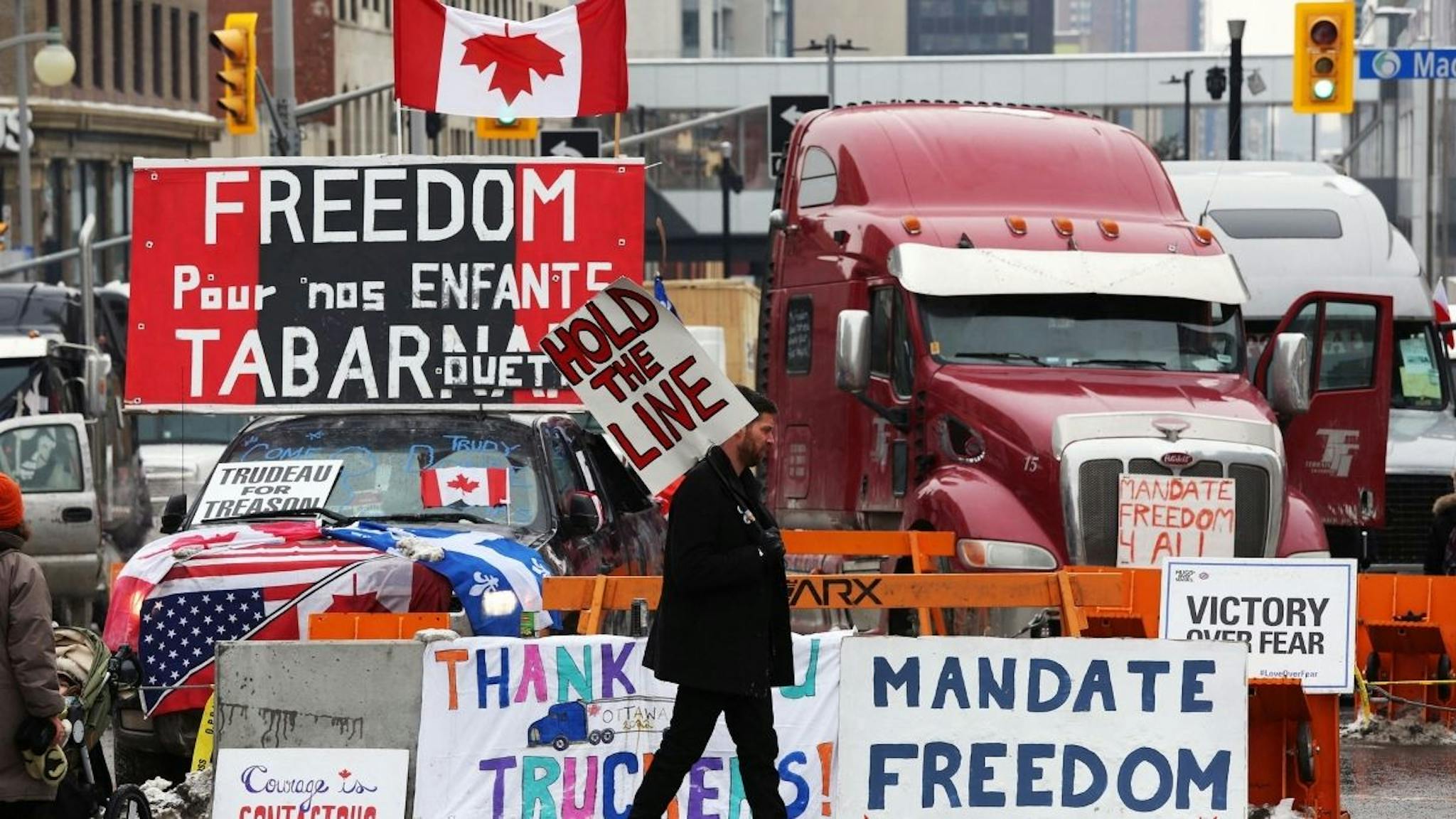 freedom convoy A protester walks in front of parked trucks as demonstrators continue to protest the vaccine mandates implemented by Prime Minister Justin Trudeau on February 8, 2022 in Ottawa, Canada.
