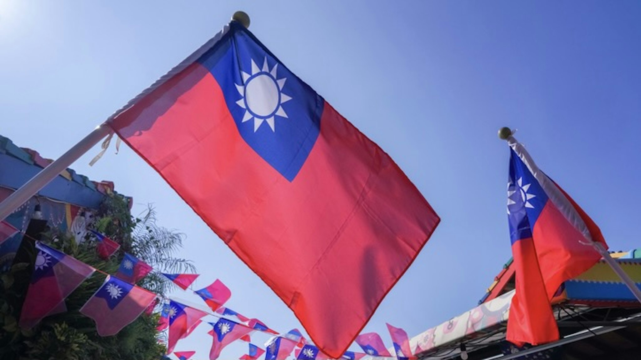 Taiwanese national flags against clear blue sky - stock photo Taiwan is small island country in east Asia, this photo was taken at rainbow village in Taichung the second largest city in Taiwan pratan ounpitipong via Getty Images