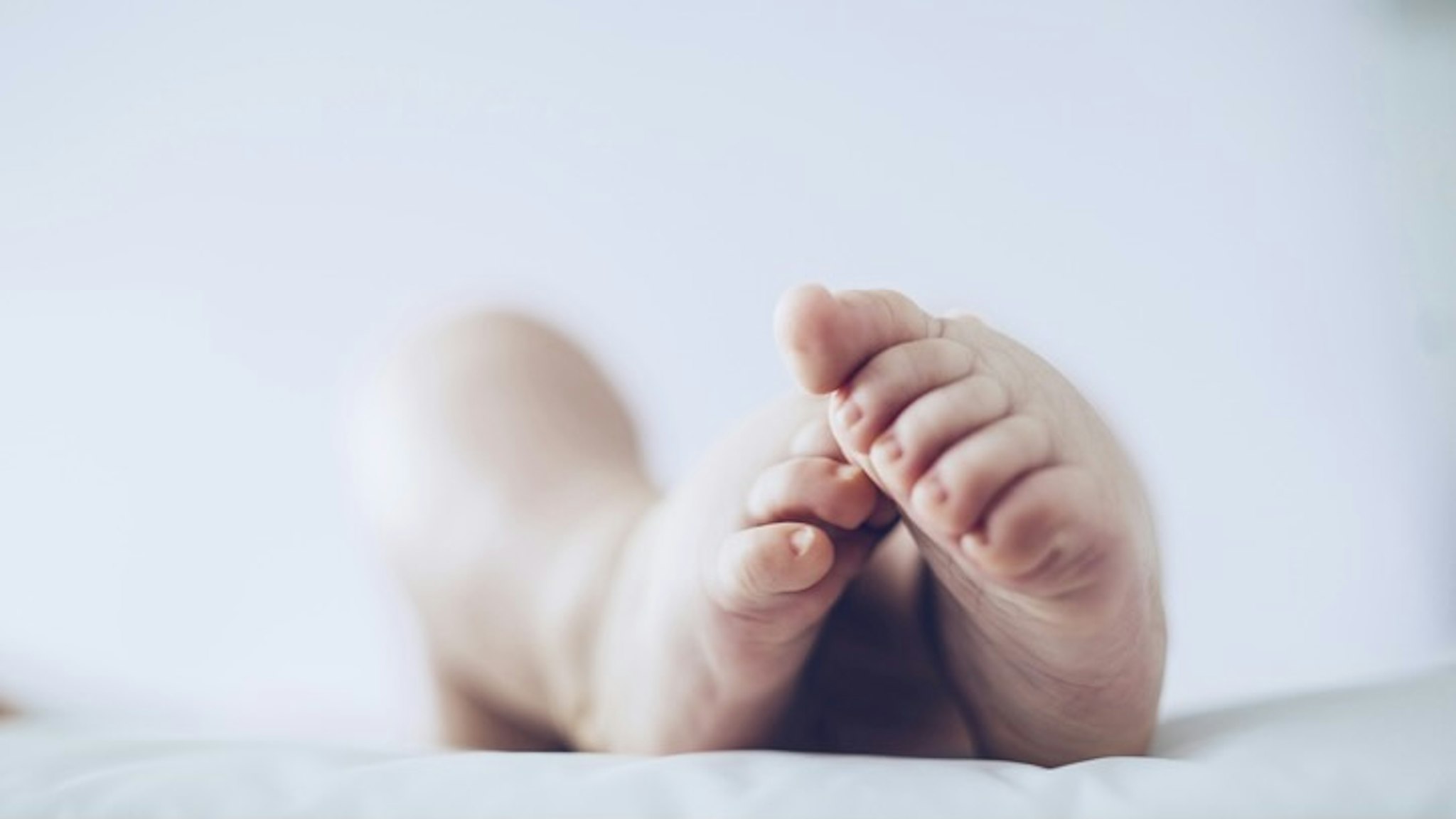 Baby feet. - stock photo Baby feet up in the air lying down. Guido Mieth via Getty Images