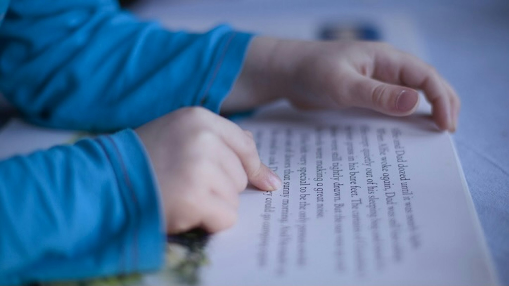close up boys fingers pointing to words in book - stock photo Gary John Norman via Getty Images