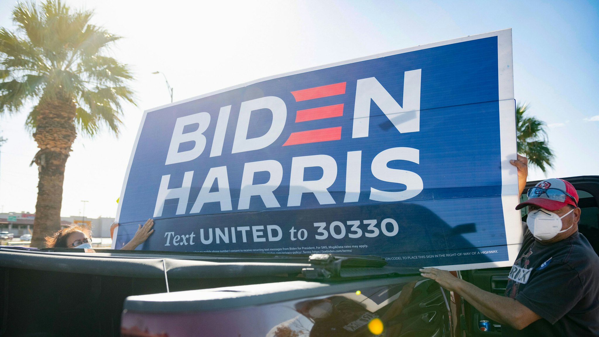 A man holds a Biden-Harris poster as he gets ready for a Protect Our Vote car caravan at David Ortiz Park in El Paso, Texas in celebration of president-elect Joe Biden's victory in the 2020 presidential race on November 7, 2020. - Democrat Joe Biden has won the White House, US media said November 7, defeating Donald Trump and ending a presidency that convulsed American politics, shocked the world and left the United States more divided than at any time in decades.