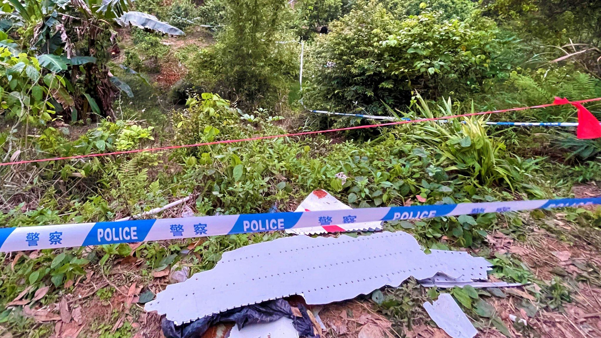 Photo taken with a mobile phone shows pieces of a crashed passenger plane's wreckage found at the crash site in Tengxian County, south China's Guangxi Zhuang Autonomous Region, March 22, 2022. A passenger plane with 132 people aboard crashed in south China's Guangxi Zhuang Autonomous Region on Monday afternoon, the regional emergency management department said. The China Eastern Airlines Boeing 737 aircraft, which departed from Kunming and was bound for Guangzhou, crashed into a mountainous area near the Molang village in Tengxian County in the city of Wuzhou at 2:38 p.m., causing a mountain fire, according to the department. The airline said the cause of the accident will be fully investigated.