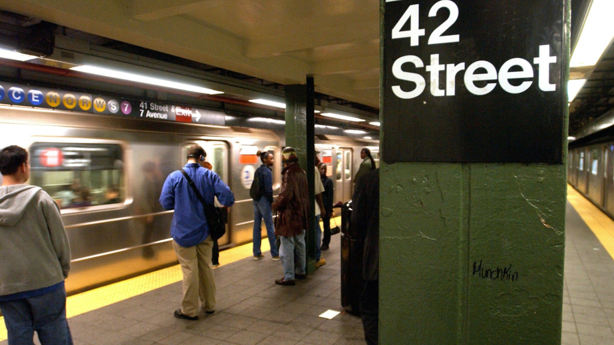 People wait for a train in a subway station June 18, 2003 in New York City.