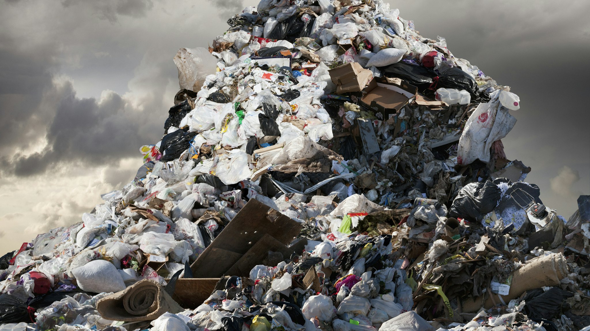 A Mountain of Garbage Looms Above - stock photo