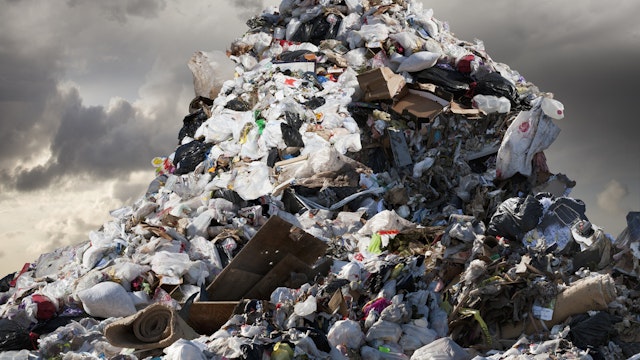 A Mountain of Garbage Looms Above - stock photo