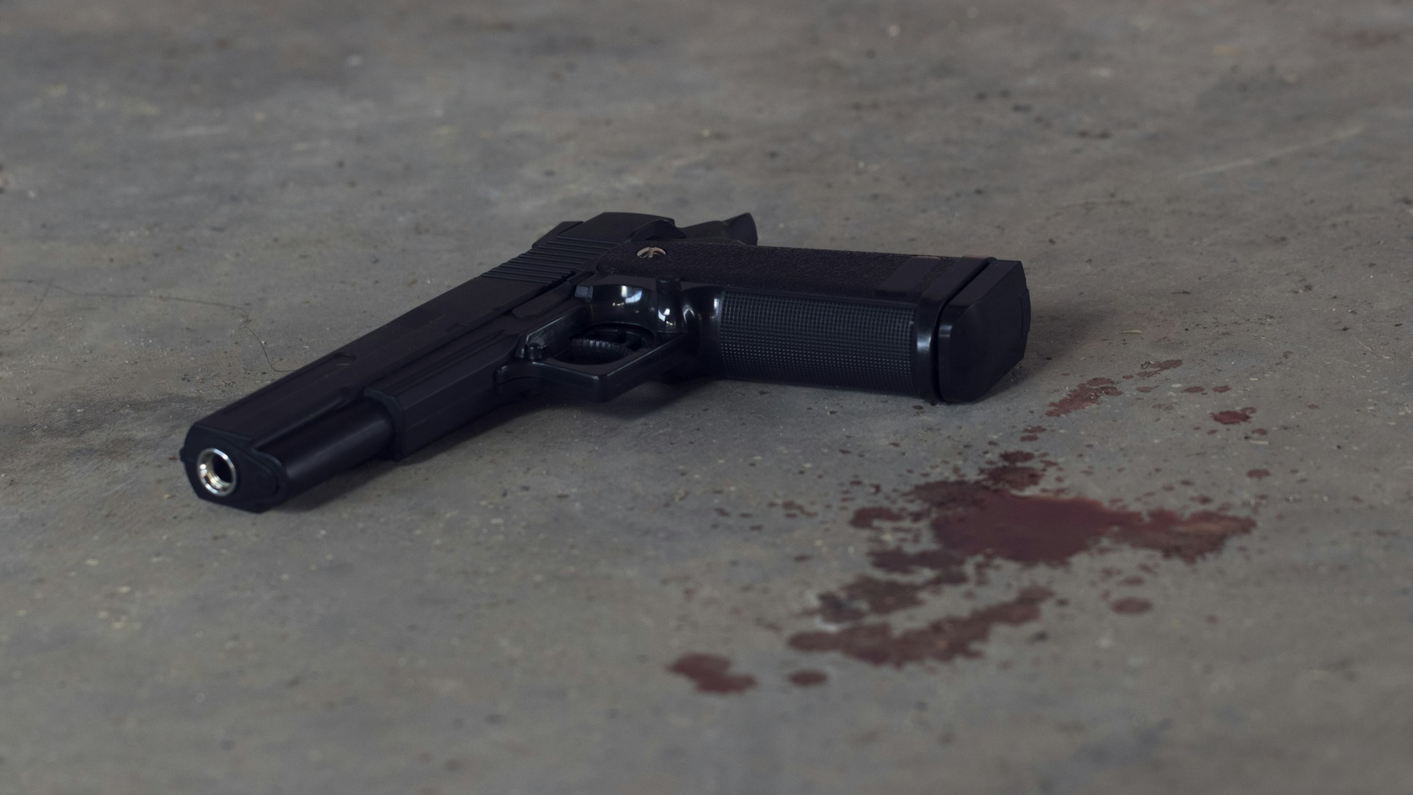 High Angle View Of Black Handgun And Blood On Floor - stock photo