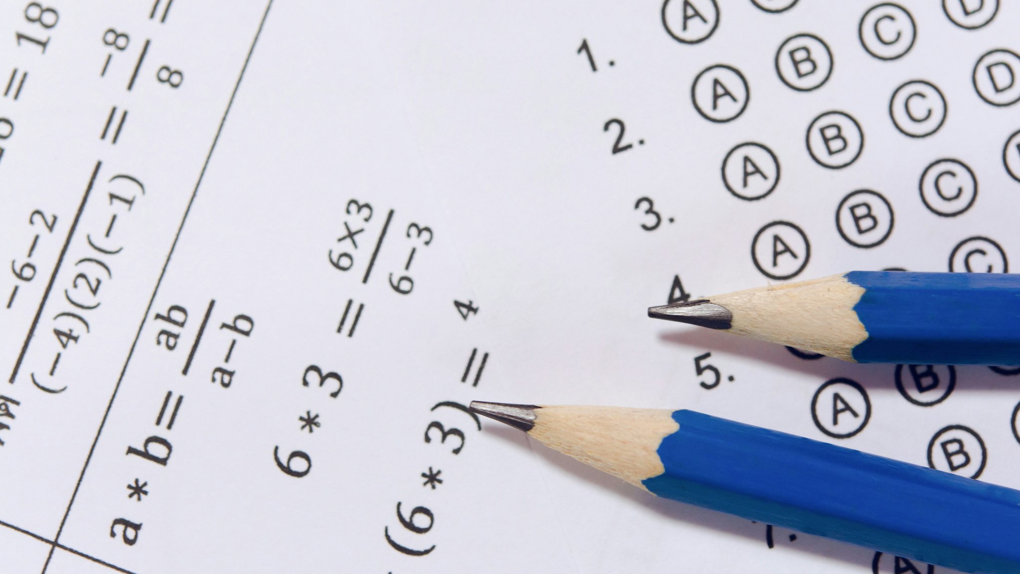 Pencil on answer sheets or Standardized test form with answers bubbled. multiple choice answer sheet - stock photo