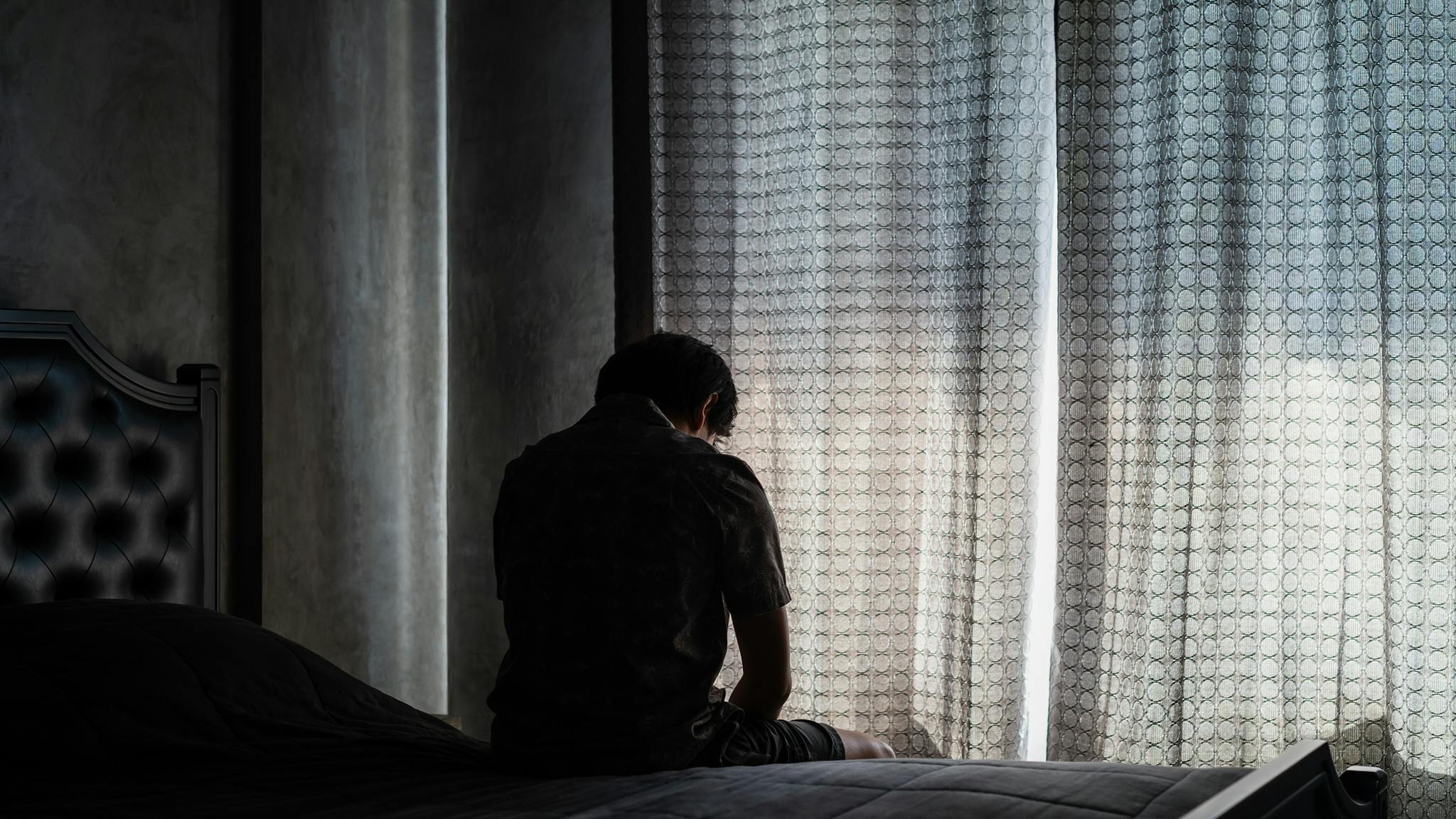 Rear View Of Man Sitting On Bed Rear View Of Man Sitting On Bed - stock photo