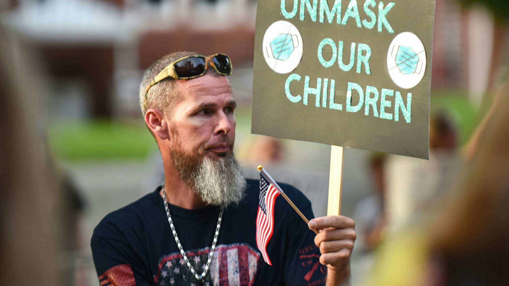 DELAND, FLORIDA, UNITED STATES - 2021/09/14: Daniel Layton holds a placard outside a meeting of the Volusia County School Board in Deland. The school board voted 3-2 to modify the mandatory school mask requirement to allow parents to opt out of the requirement for their children. (